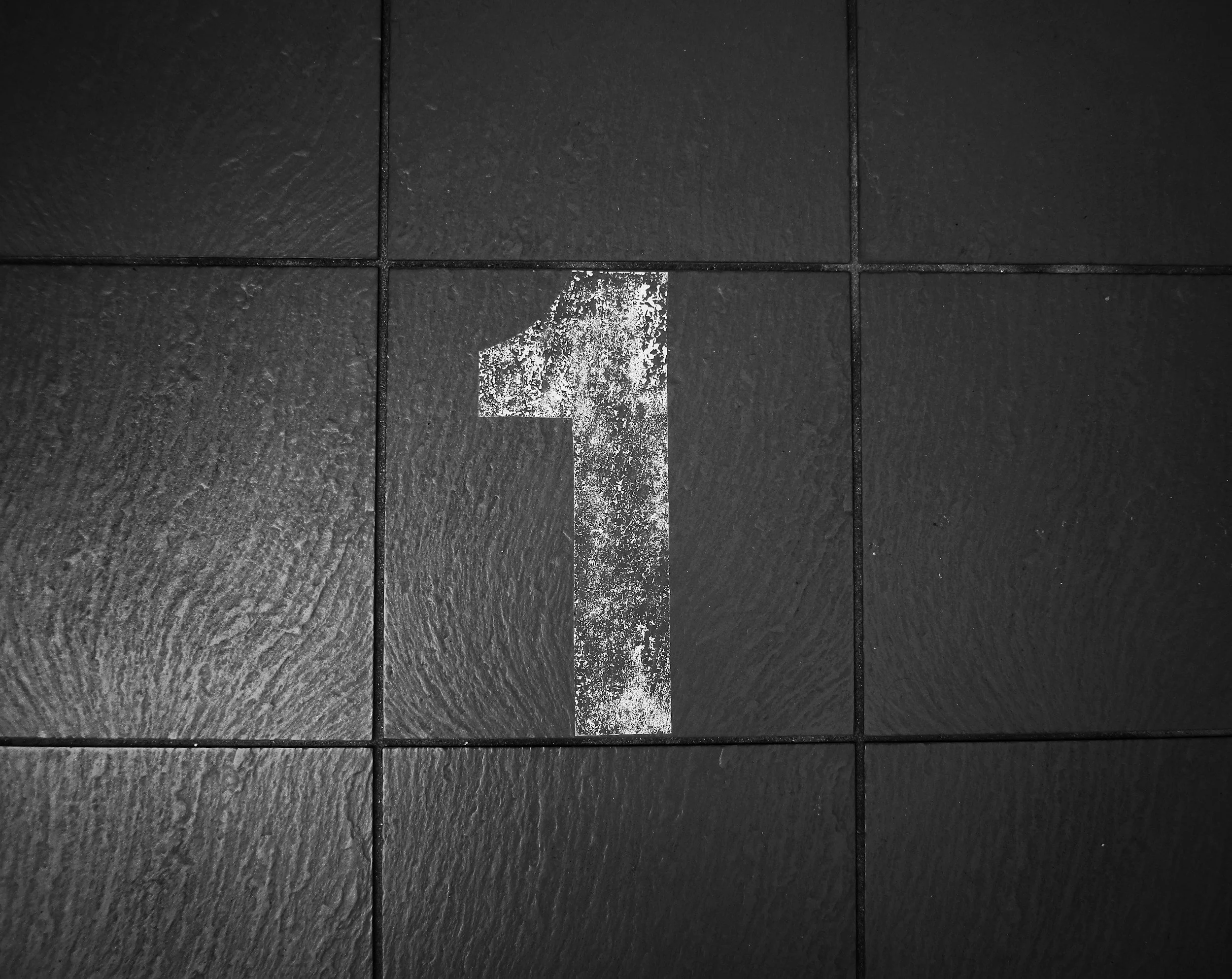 a white number 1 on a black tiled floor