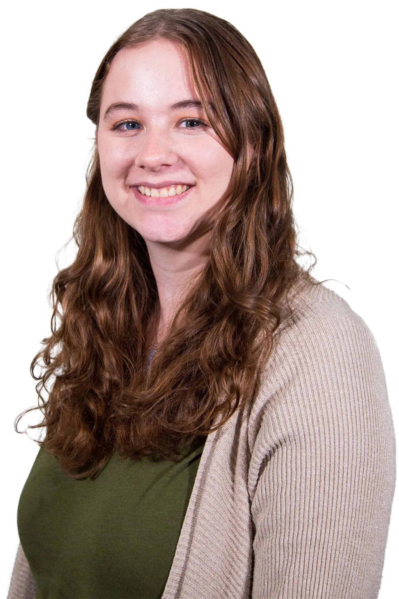 A young woman with long, curly brown hair smiling, wearing a green top and beige cardigan, against a white background.