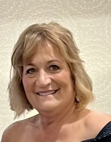 Smiling woman outdoors with trees in background