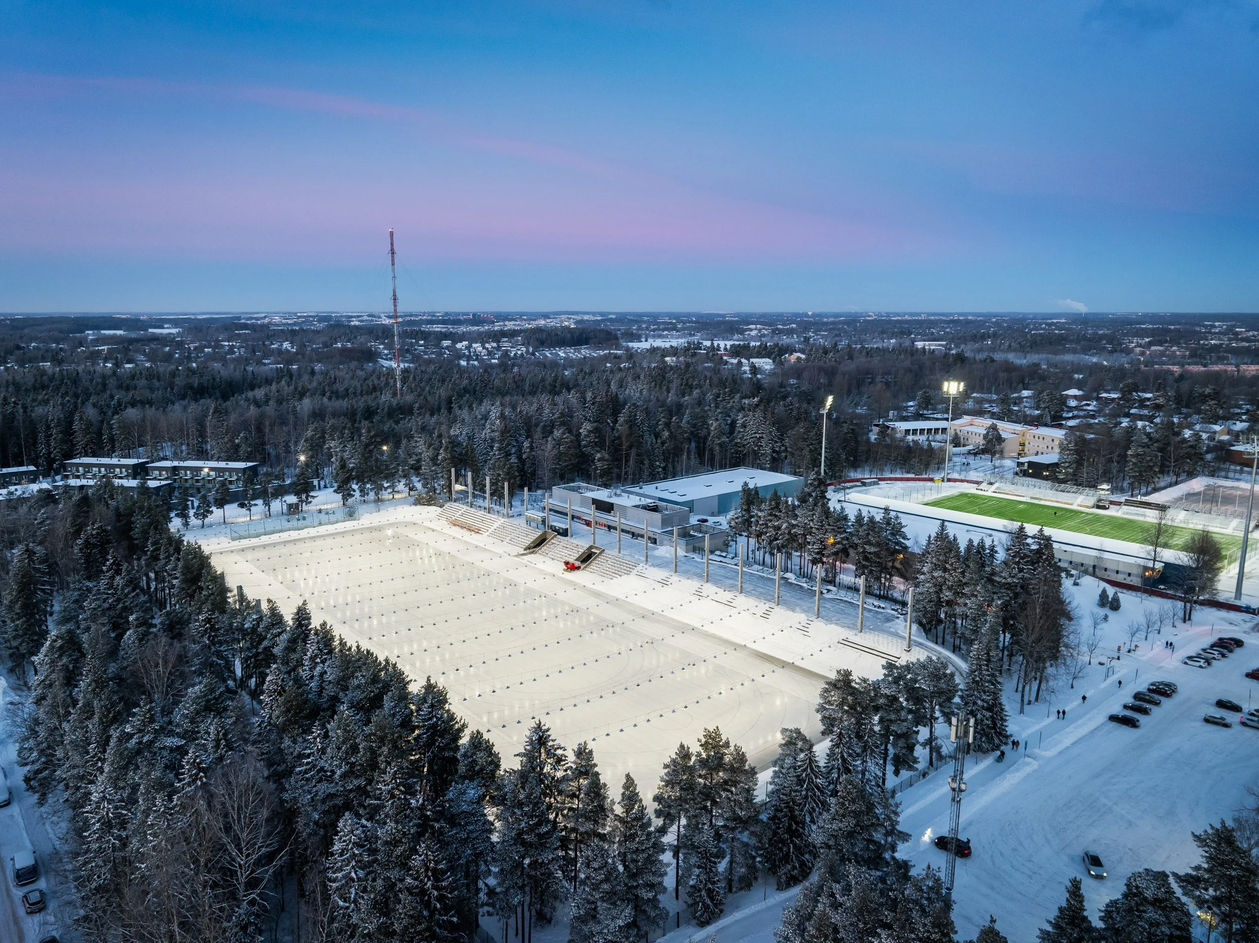 Oulunkylän liikuntakeskus ja tekojäärata kuvattuna ilmasta talviseen auringonlaskuun.