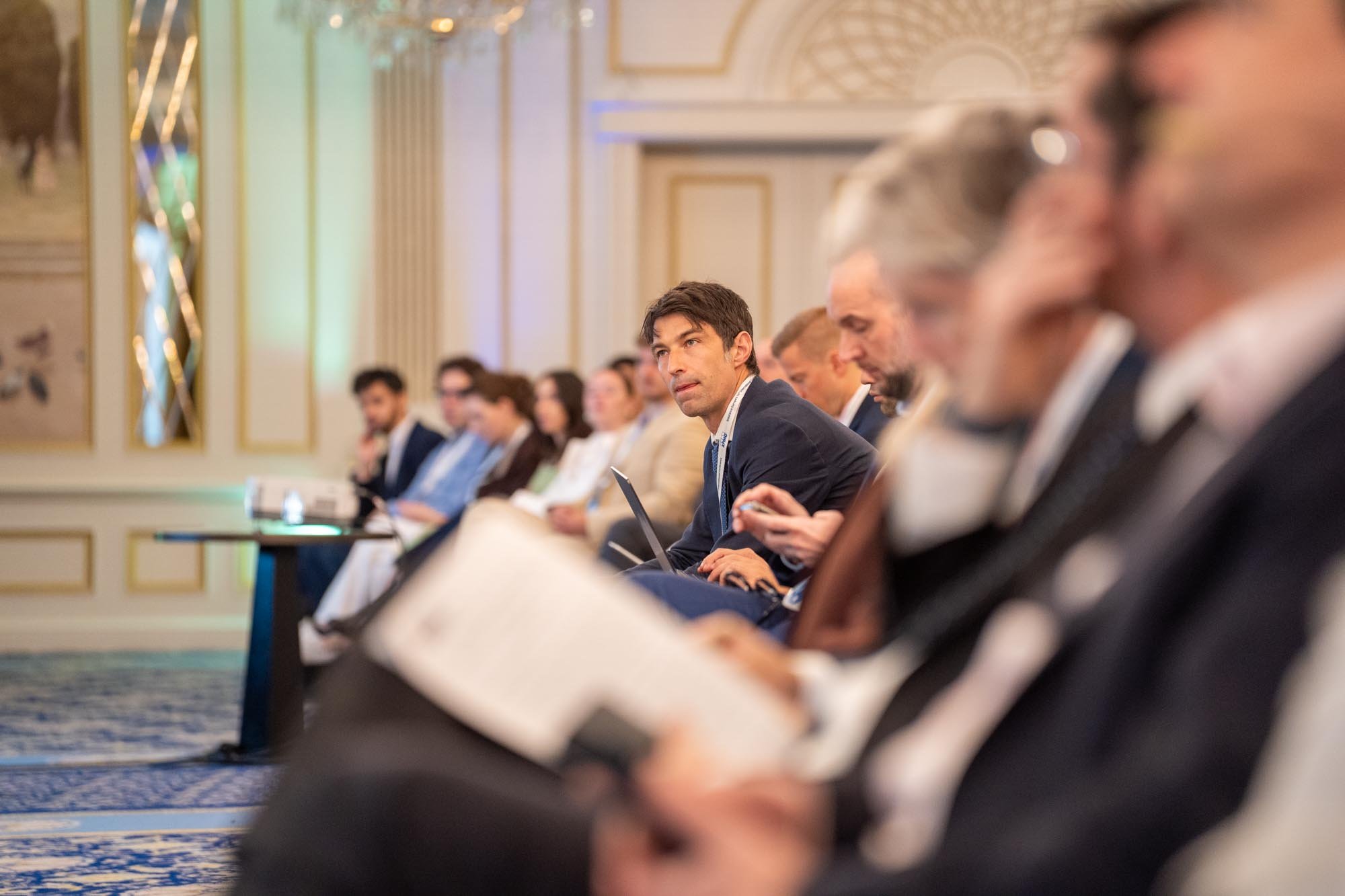 People sitting in a conference room during a professional event, listening attentively with some taking notes. Insurance Europe’s 16th International Conference at the Steigenberger Icon Wiltcher’s Hotel, Brussels.