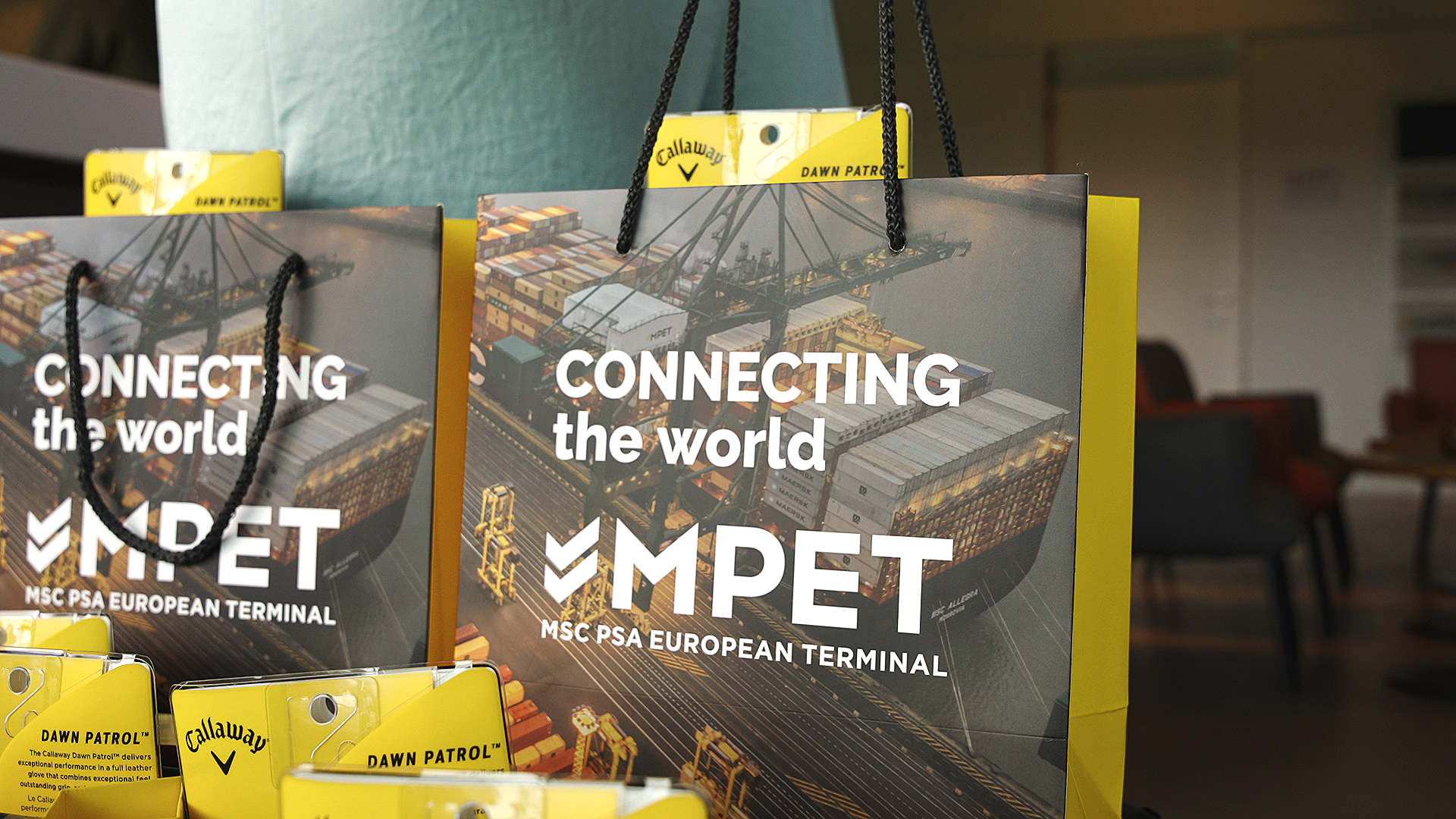 Promotional bags featuring a shipping port with containers and cranes, with the text "Connecting the world" and "MPET PSA European Terminal."