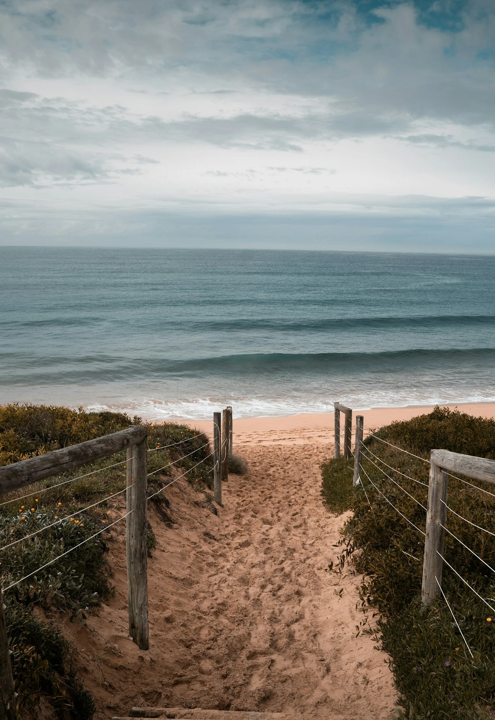 Sandy pathway leading towards the beach, representing a new journey, possibility and taking the next step.