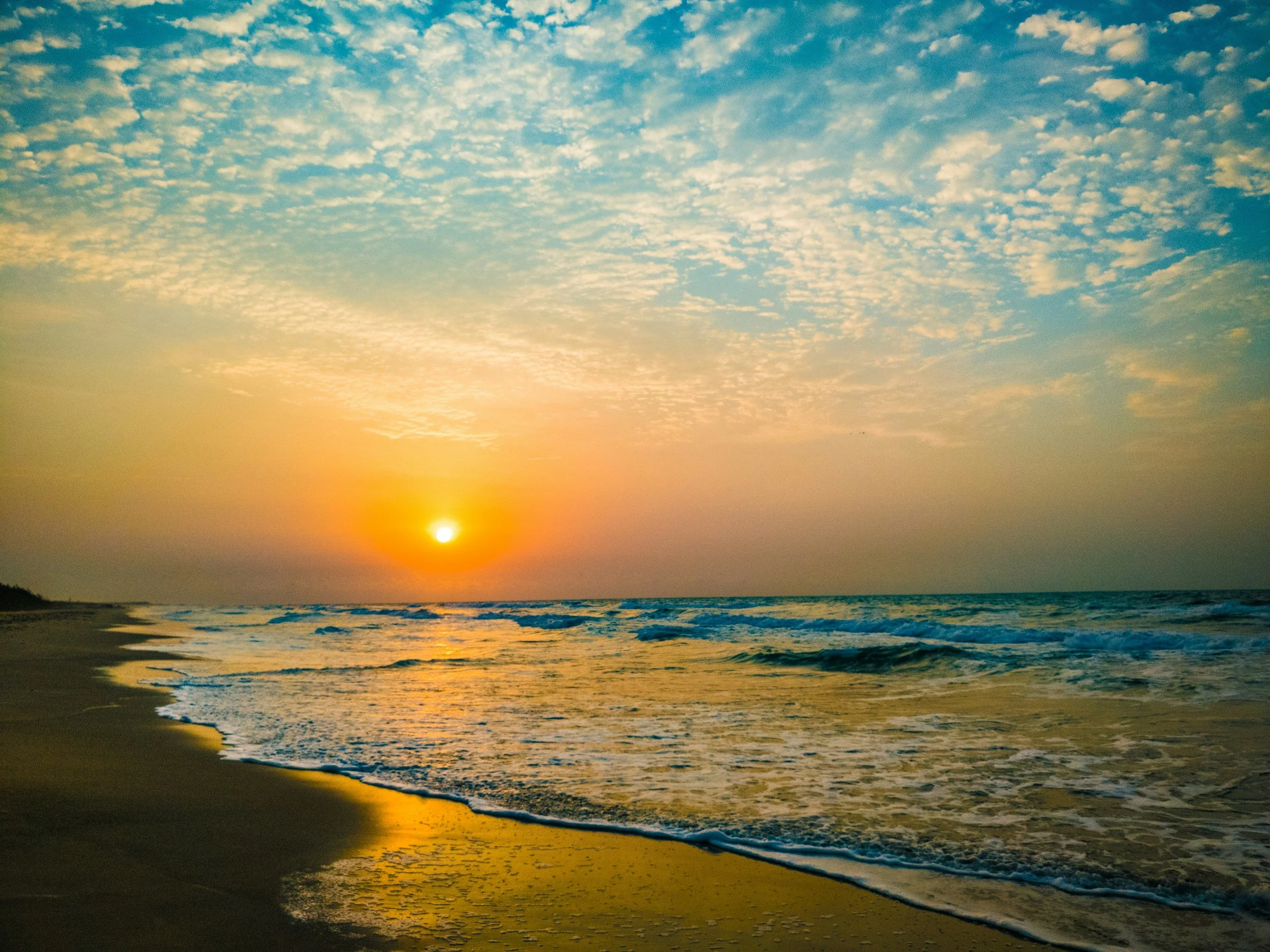 Warm sunset light across the sea and coastline.