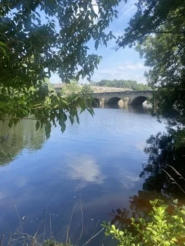 The River Wharfe in Otley with a stone bridge crossing the water.