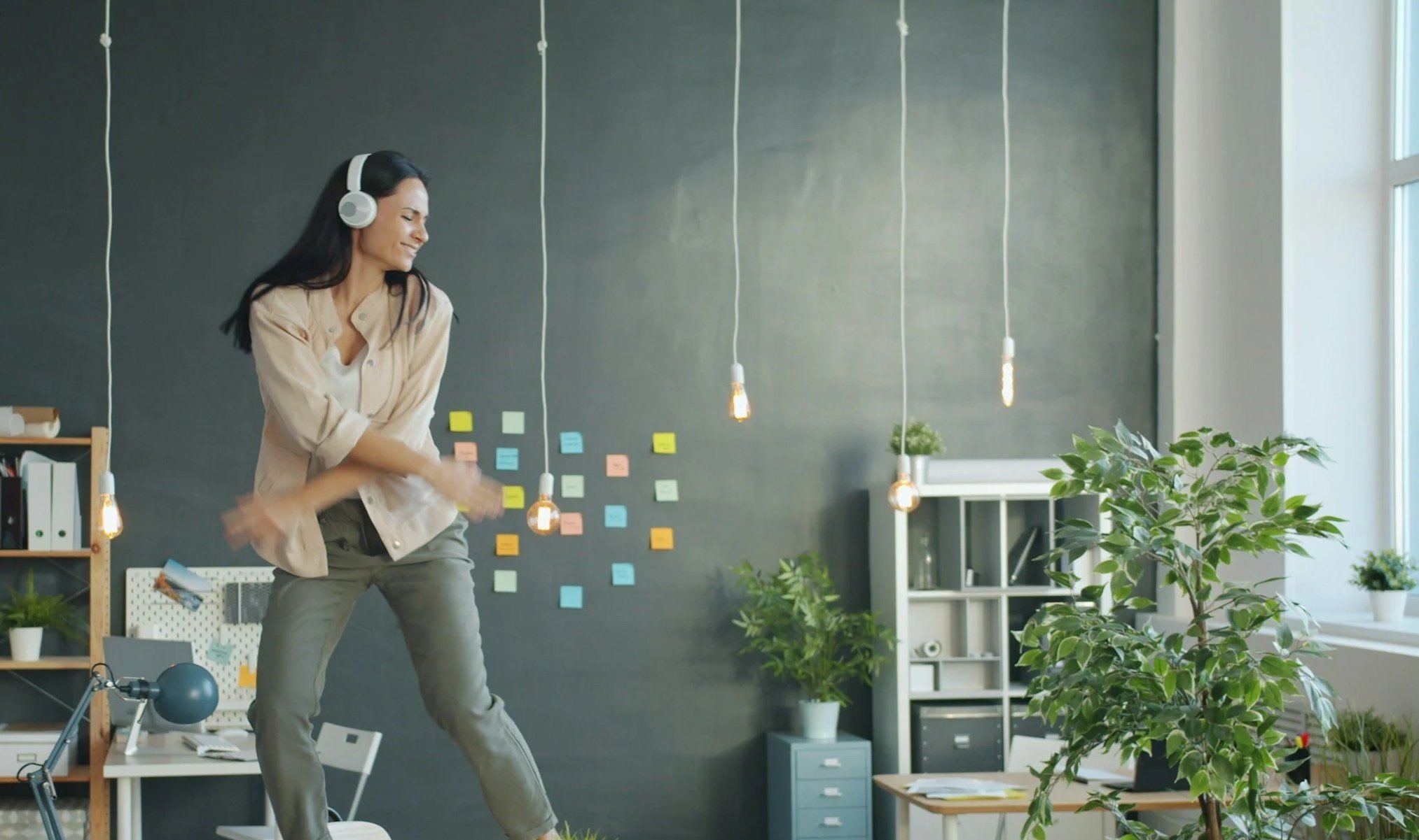 Employee feeling happy and energised while working at a desk, representing positive workplace wellbeing and a healthy work culture