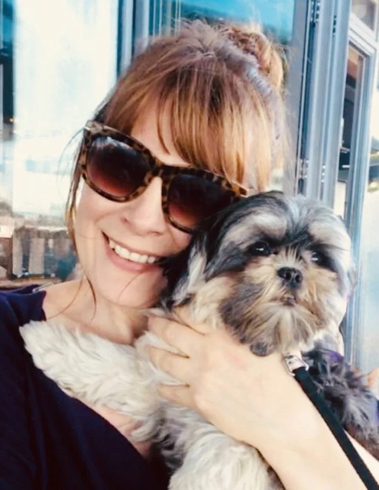 Sam Richardson smiling outdoors with her dog, sharing a warm and personal moment beyond her coaching work.
