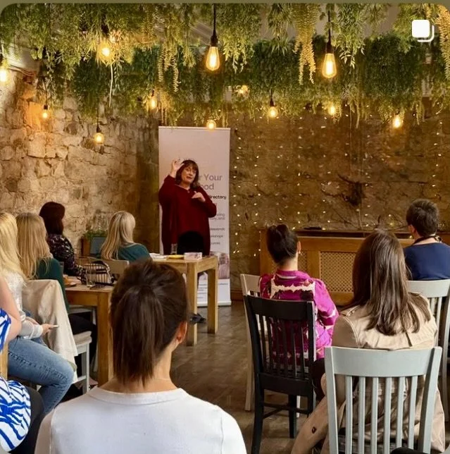 Sam Richardson speaking with an audience member at an event about confidence and self-belief.