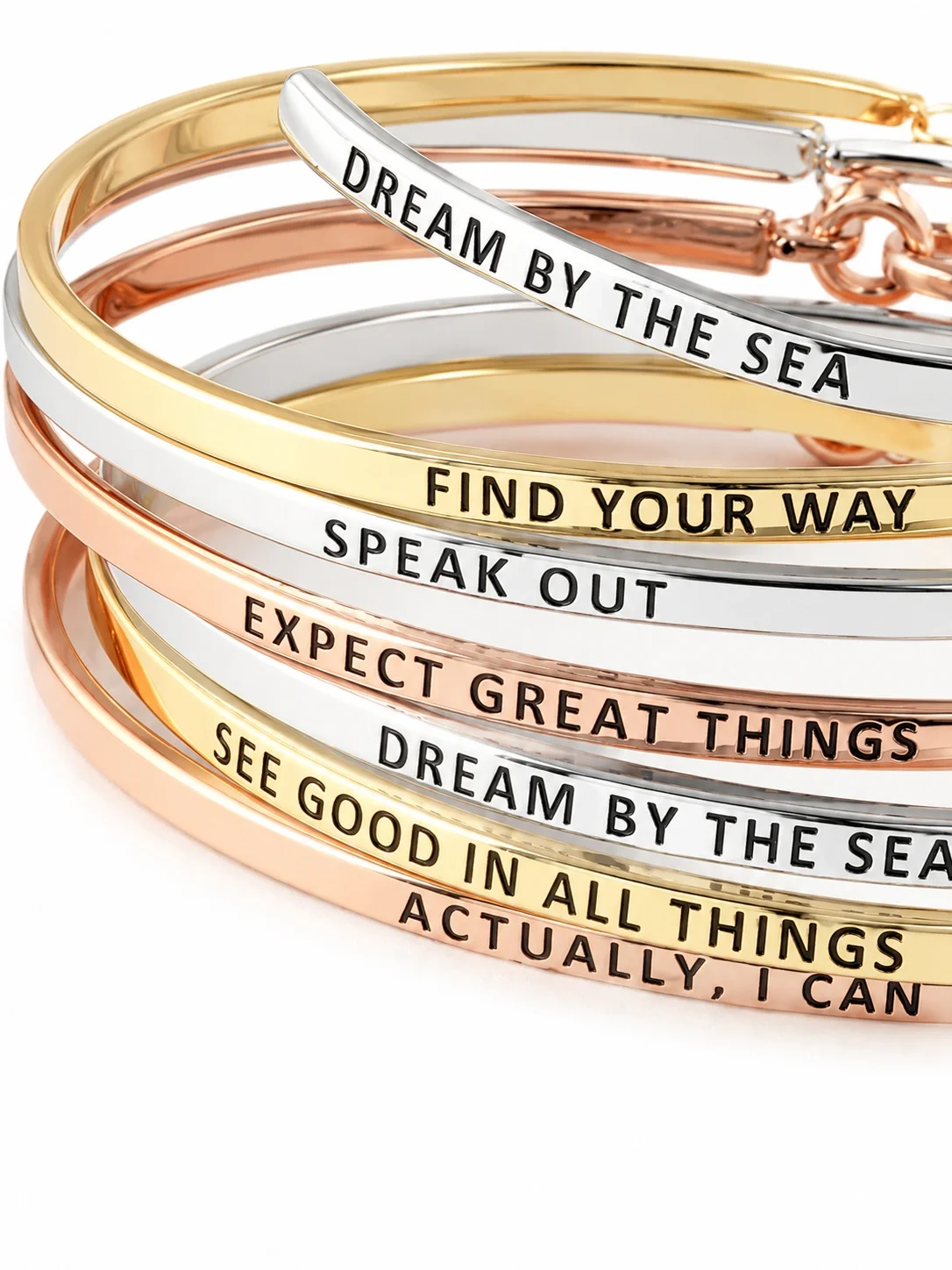 Stacked colorful bracelets with inspirational quotes including "Dream by the sea," "Find your way," "Speak out," "Expect great things," and "See good in all things."