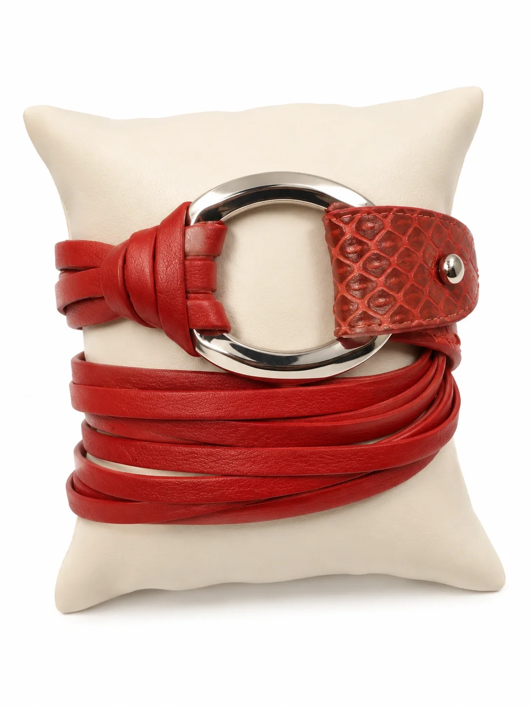 Red leather belt with a large silver buckle, wrapped around a white cushion.