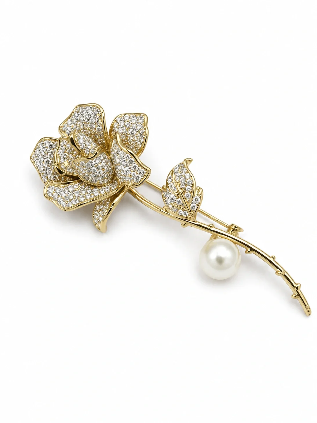 pavé rose brooch features sparkling clear rhinestones set in a gold-tone finish with a single pearl accent