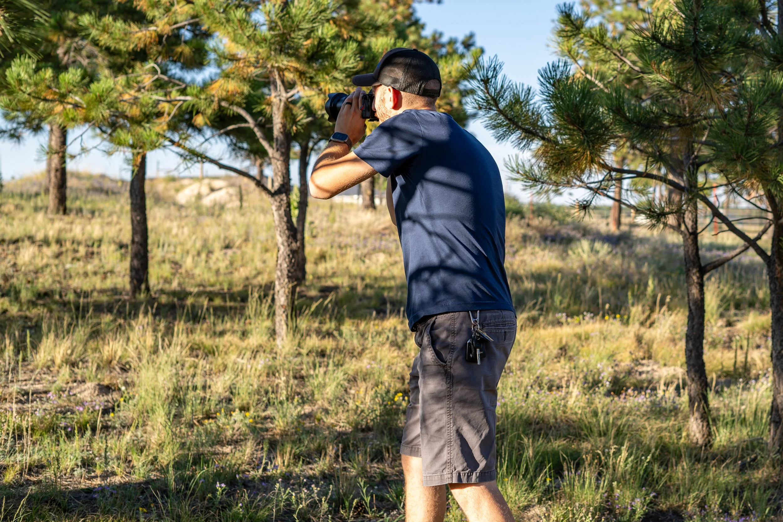 Alex Vassios taking a photo outdoors on a sunny day