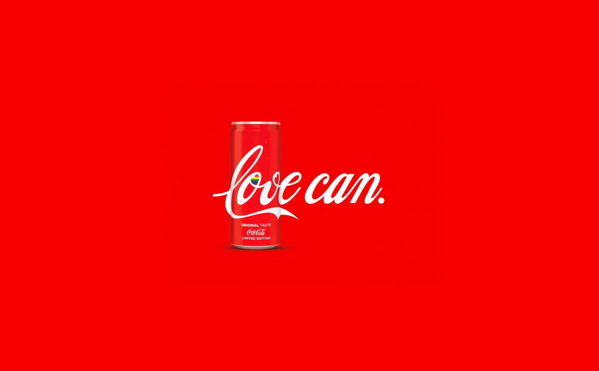 Red background with a can of Coca-Cola on display, featuring the text 'love cam' with a rainbow-colored heart inside the 'o' and additional text indicating it is a limited edition.