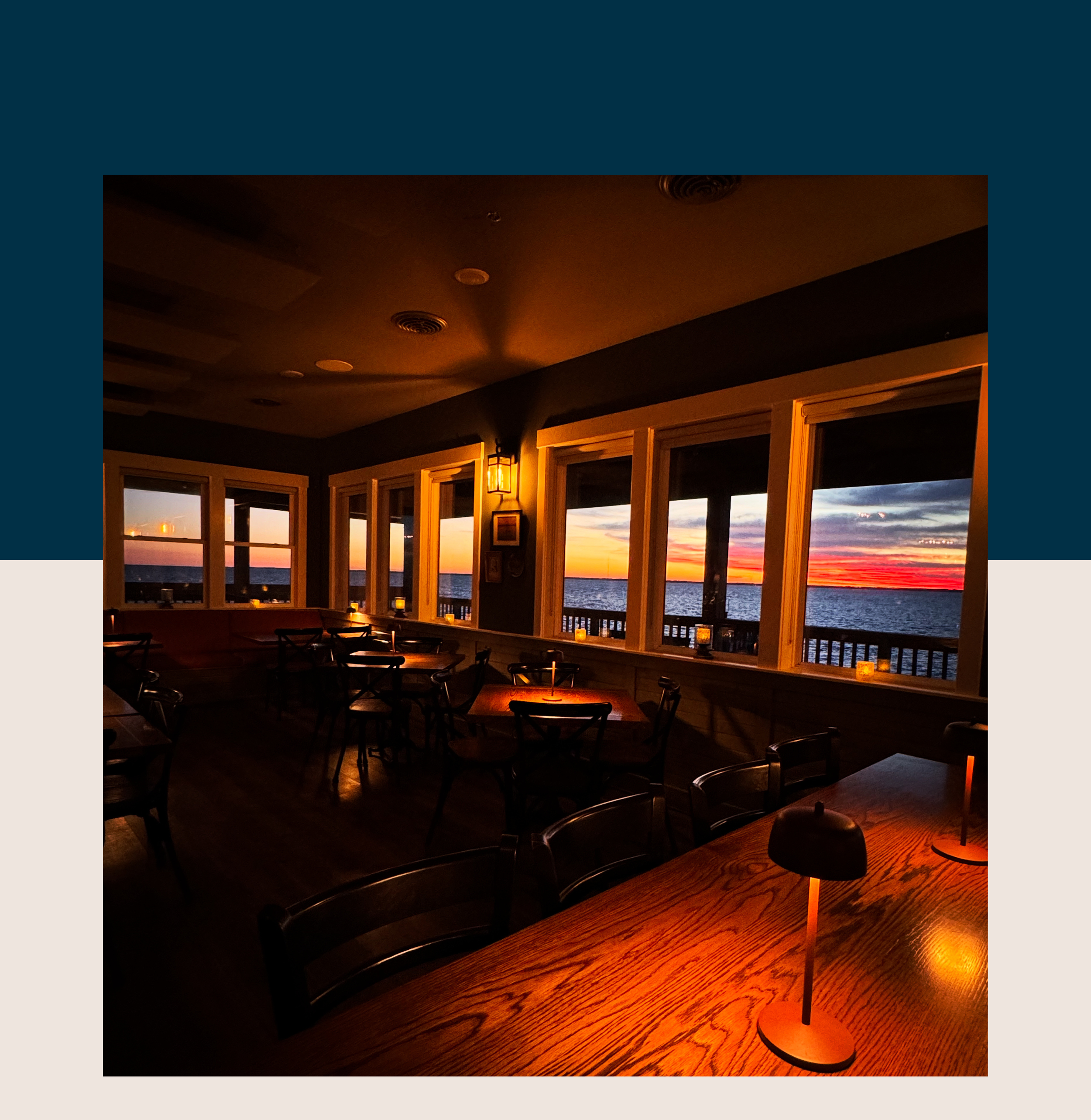 restaurant tables with a view of the sunset over water