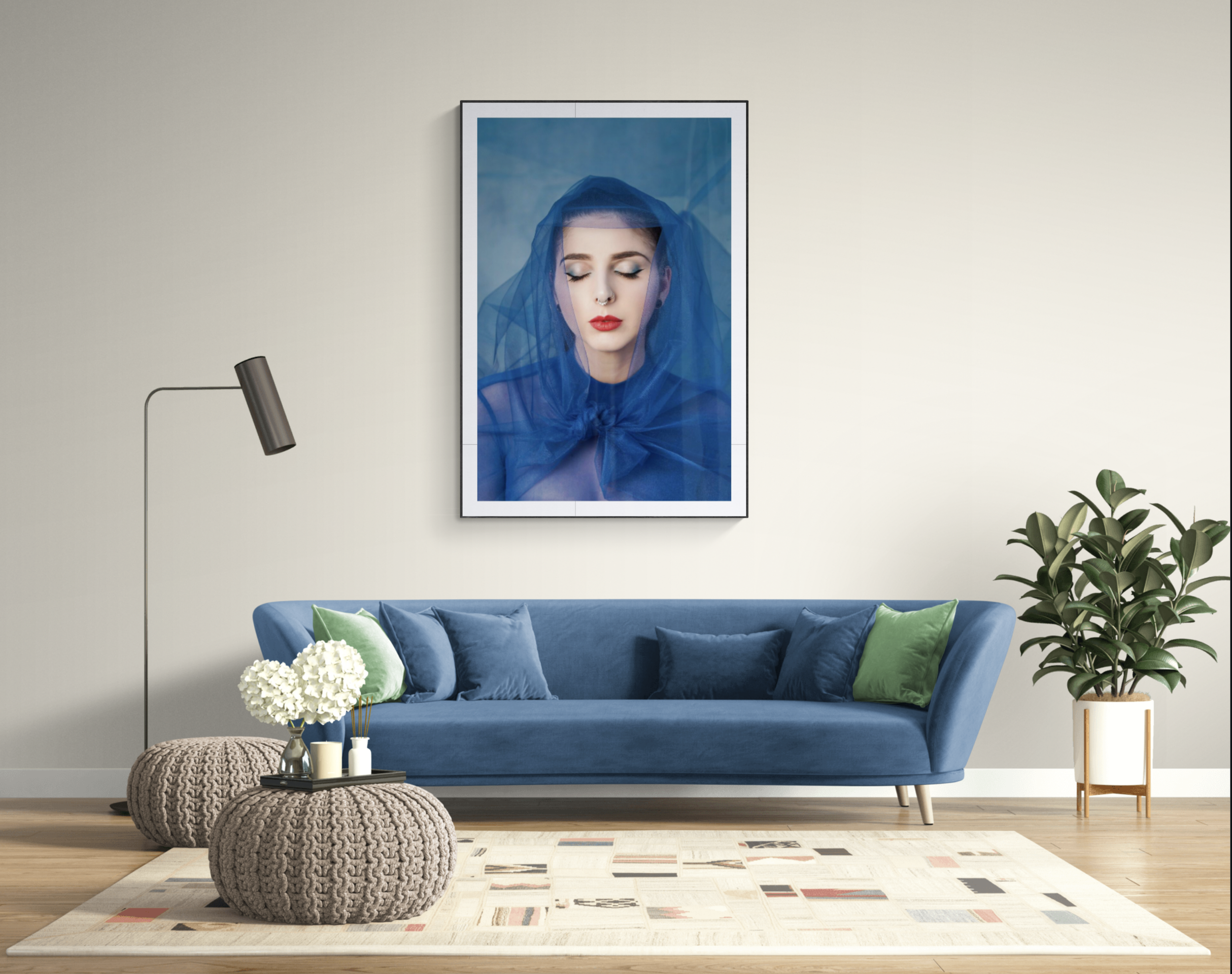 Modern living room interior with blue sofa, wall art of person in blue veil, floor lamp, poufs, coffee table with flowers, and indoor plant.