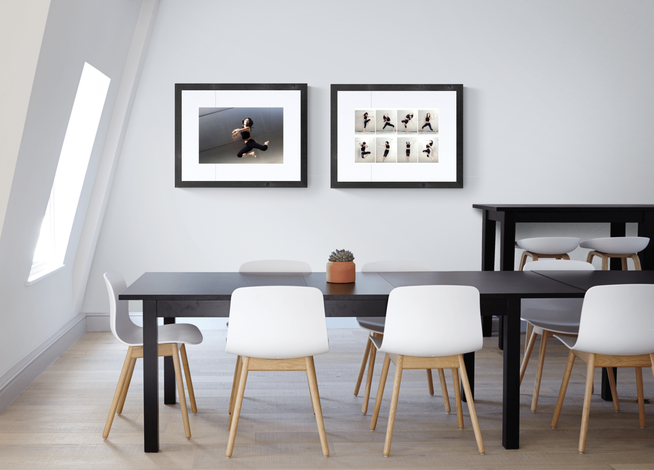 Minimalist dining area with black table, white chairs, and modern art on the wall.