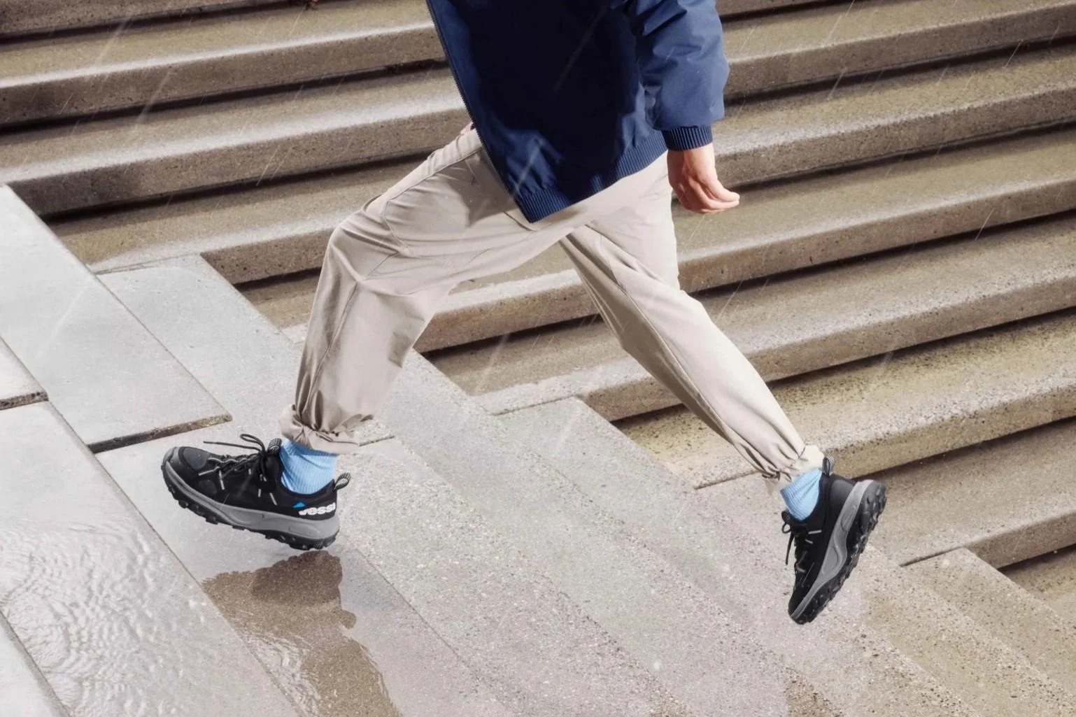 mist-jacket-blue-motu-sneakers-male-model-walking-up-stairs.jpg