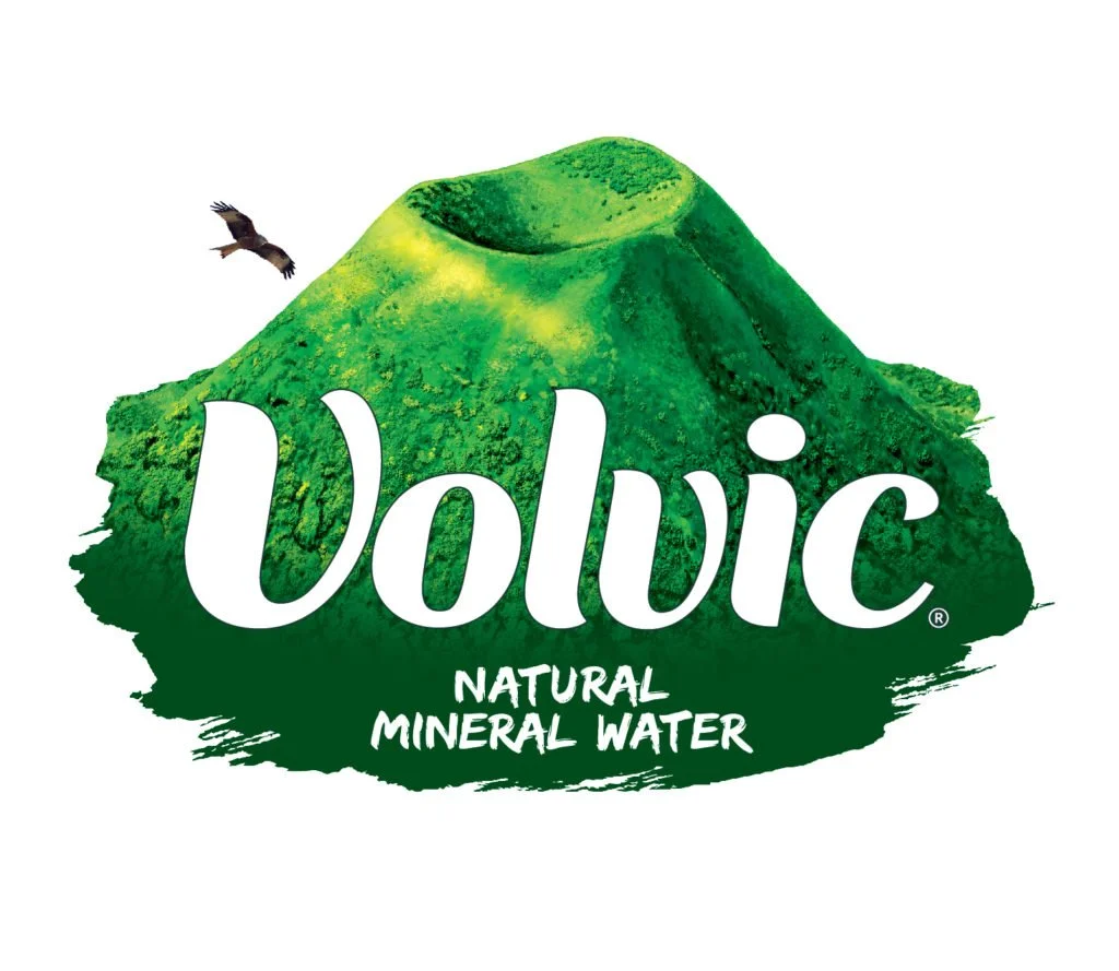 A green mountain with a hollow top, resembling a volcano, with a bird flying nearby. The text 'Volvic Natural Mineral Water' is written across the mountain.