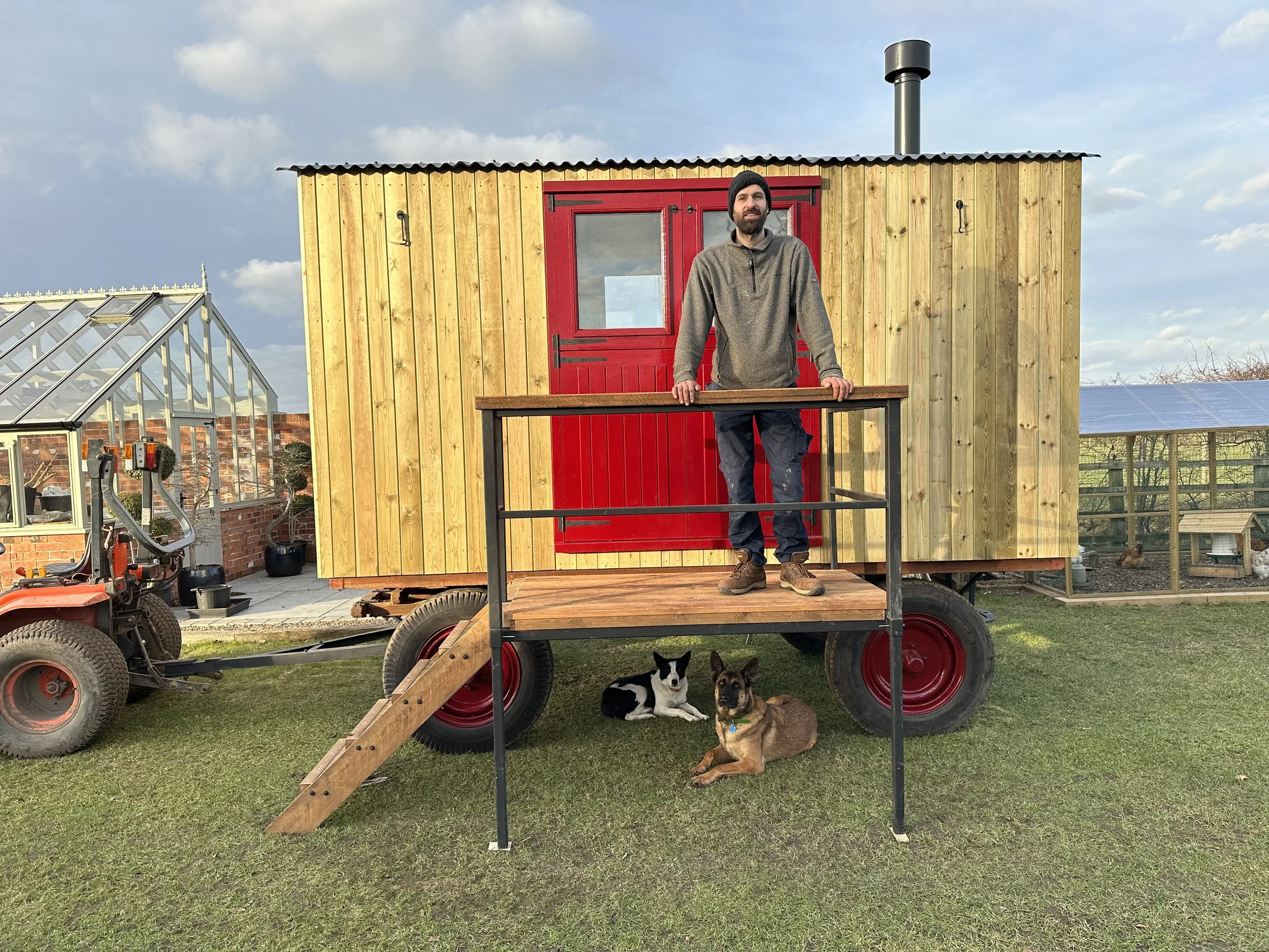 Stephs Cabins - Steph with dogs under hut.jpg