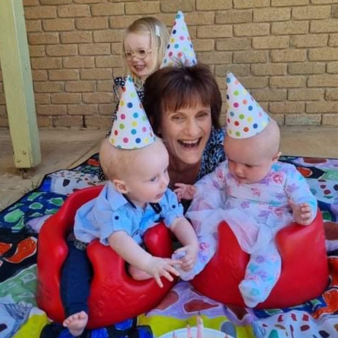 Meg Gillespie centre, smiling with joy, surrounded by her grandchildren Macey, Robbie, and Sibella