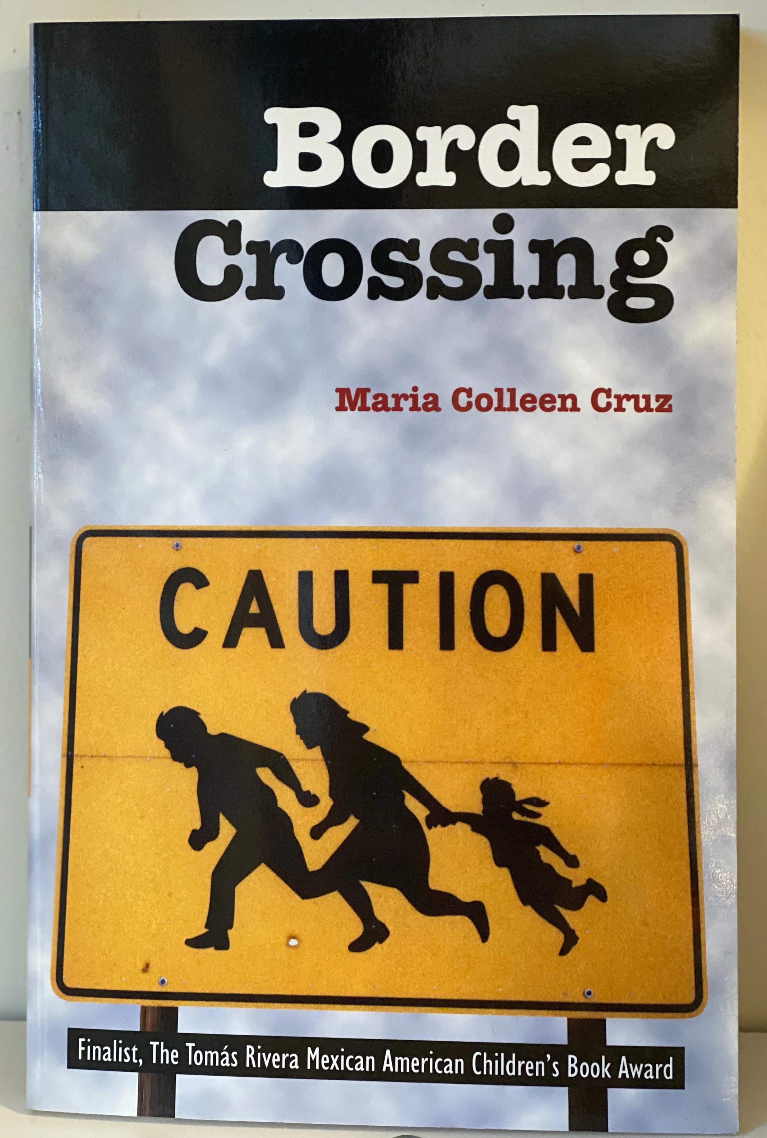 Cover with yellow border crossing sign of family running