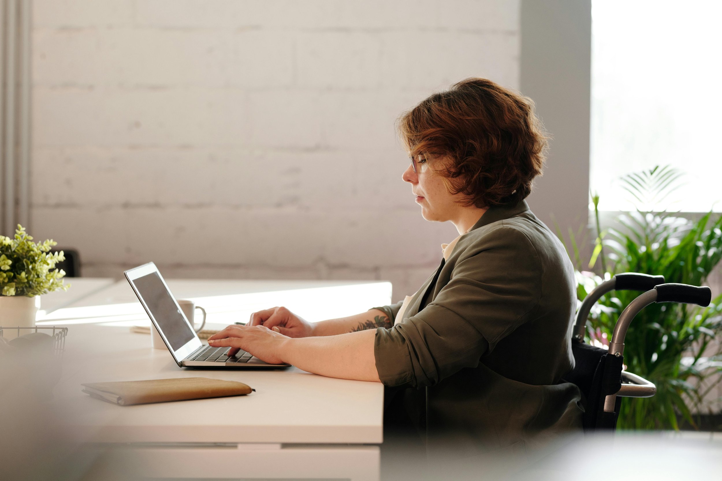 Woman in front of laptop computer looking quietly assured as she types away.