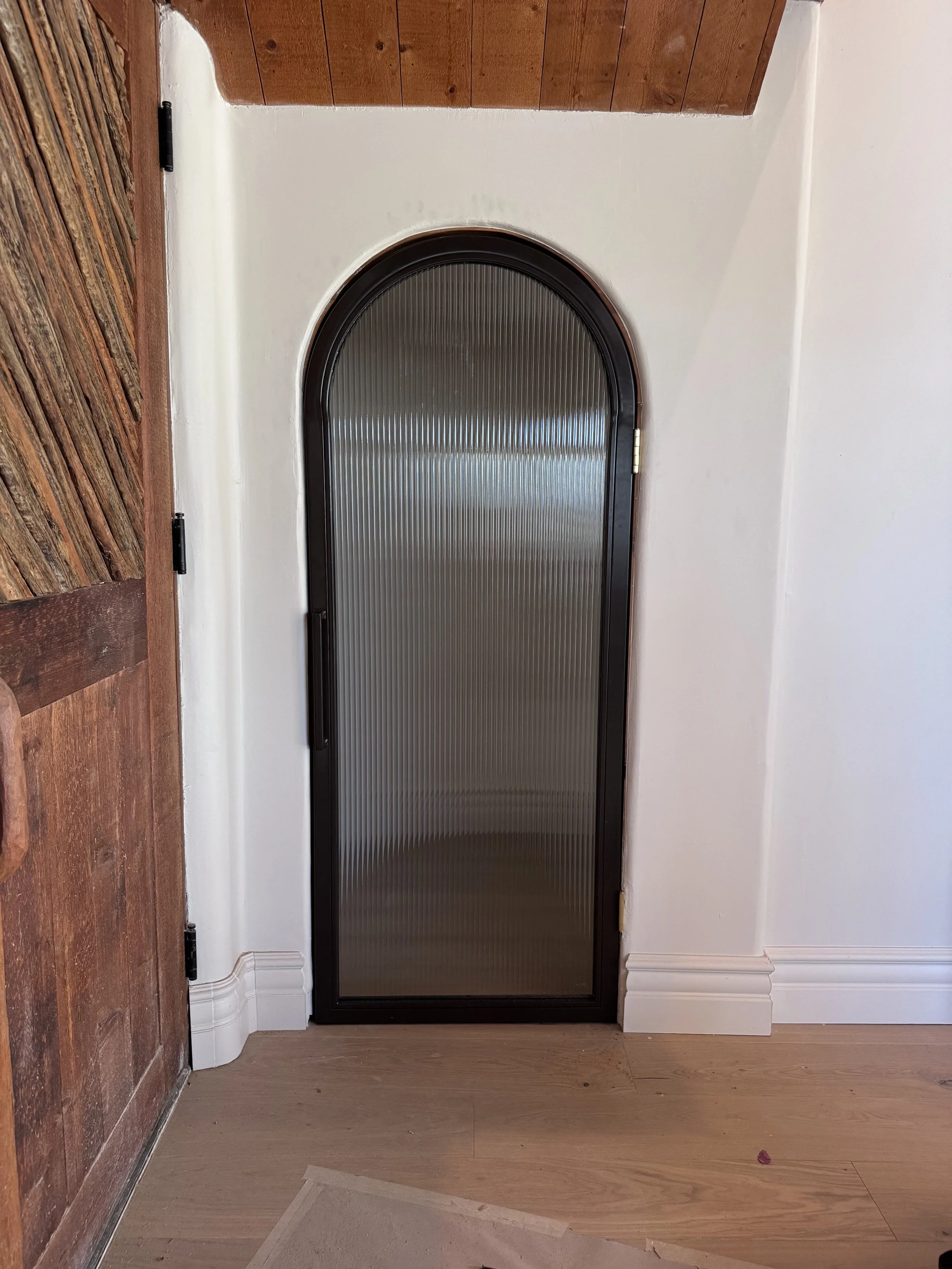 Custom arched steel door with reeded glass