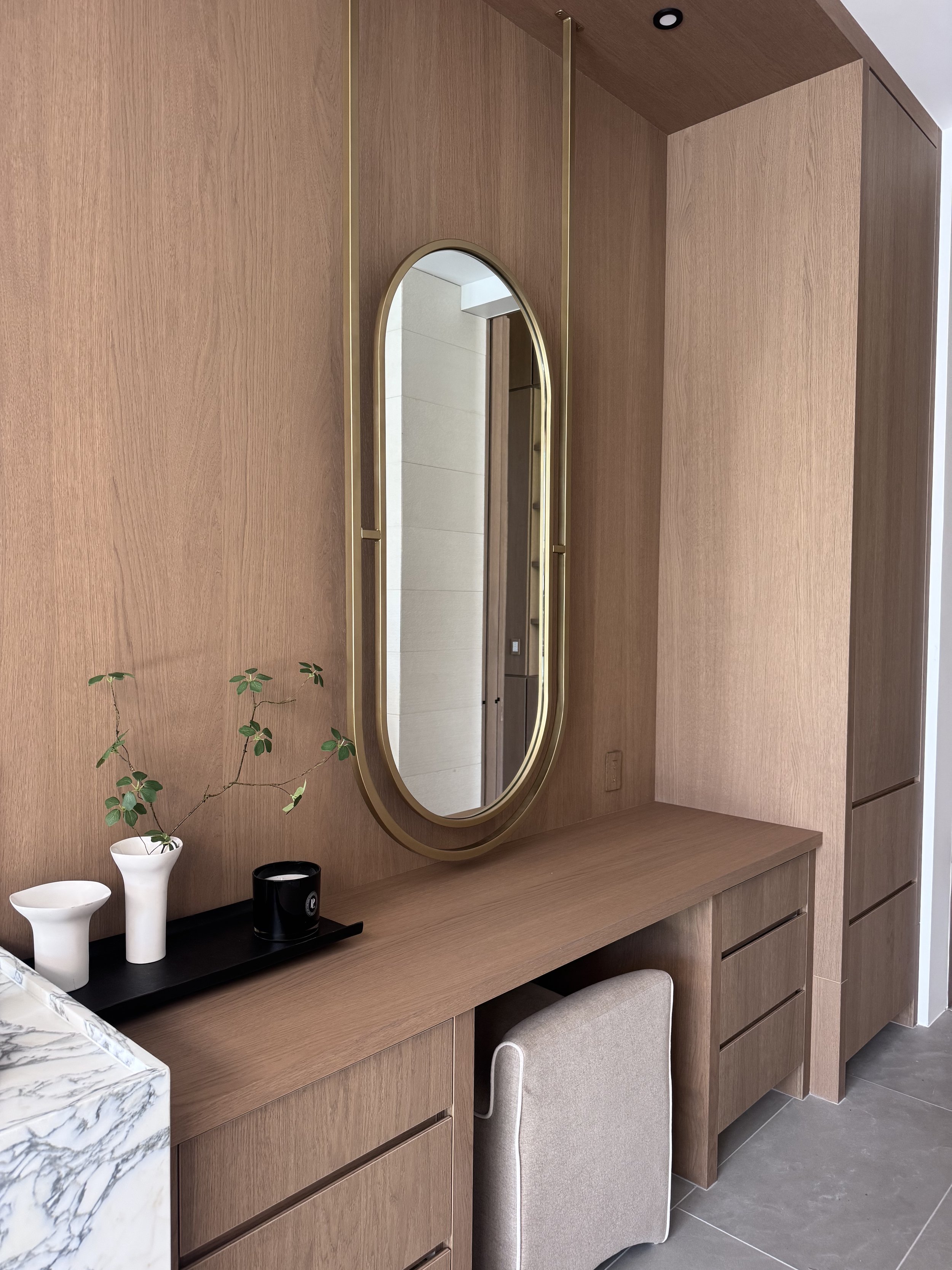 Custom brass and steel oval mirror frame over vanity