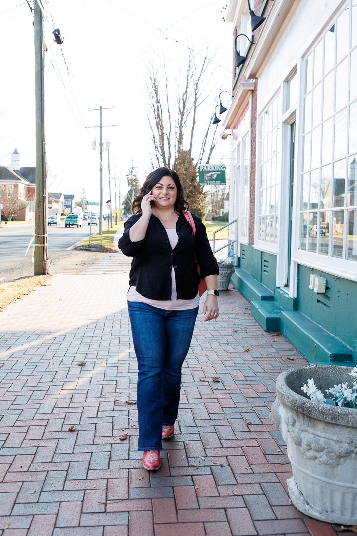 Small business owner walking on sidewalk talking on phone
