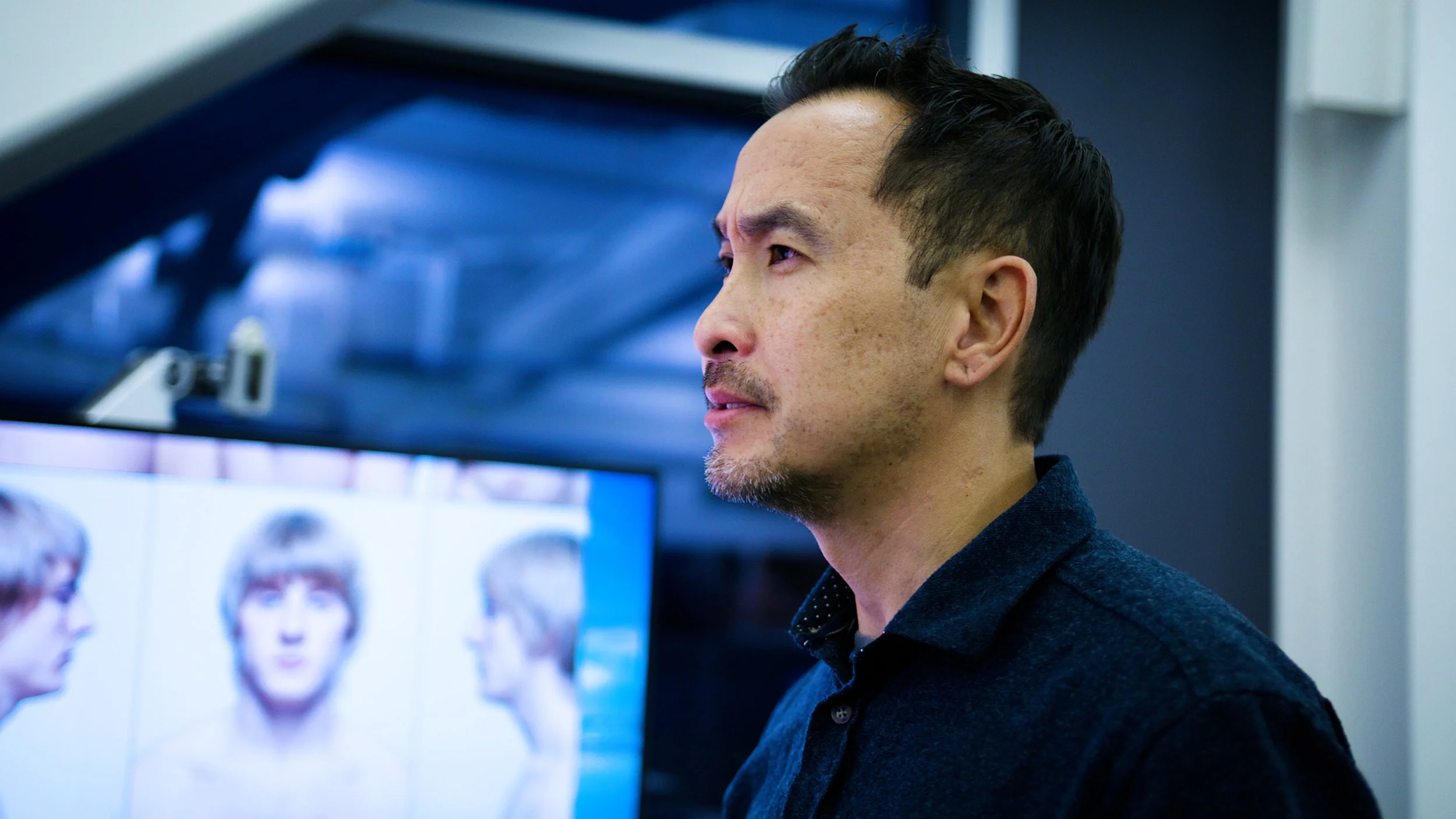 Developer looking at a screen displaying a 3D fighter character model in a studio workspace.