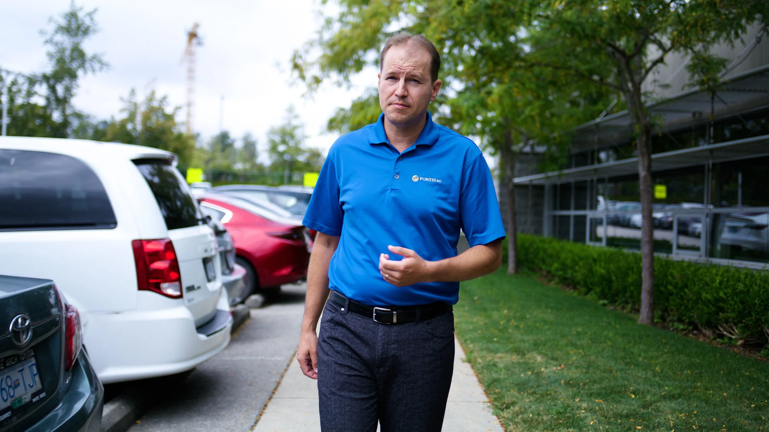 FortisBC employee walking outside a commercial building during a filmed segment.