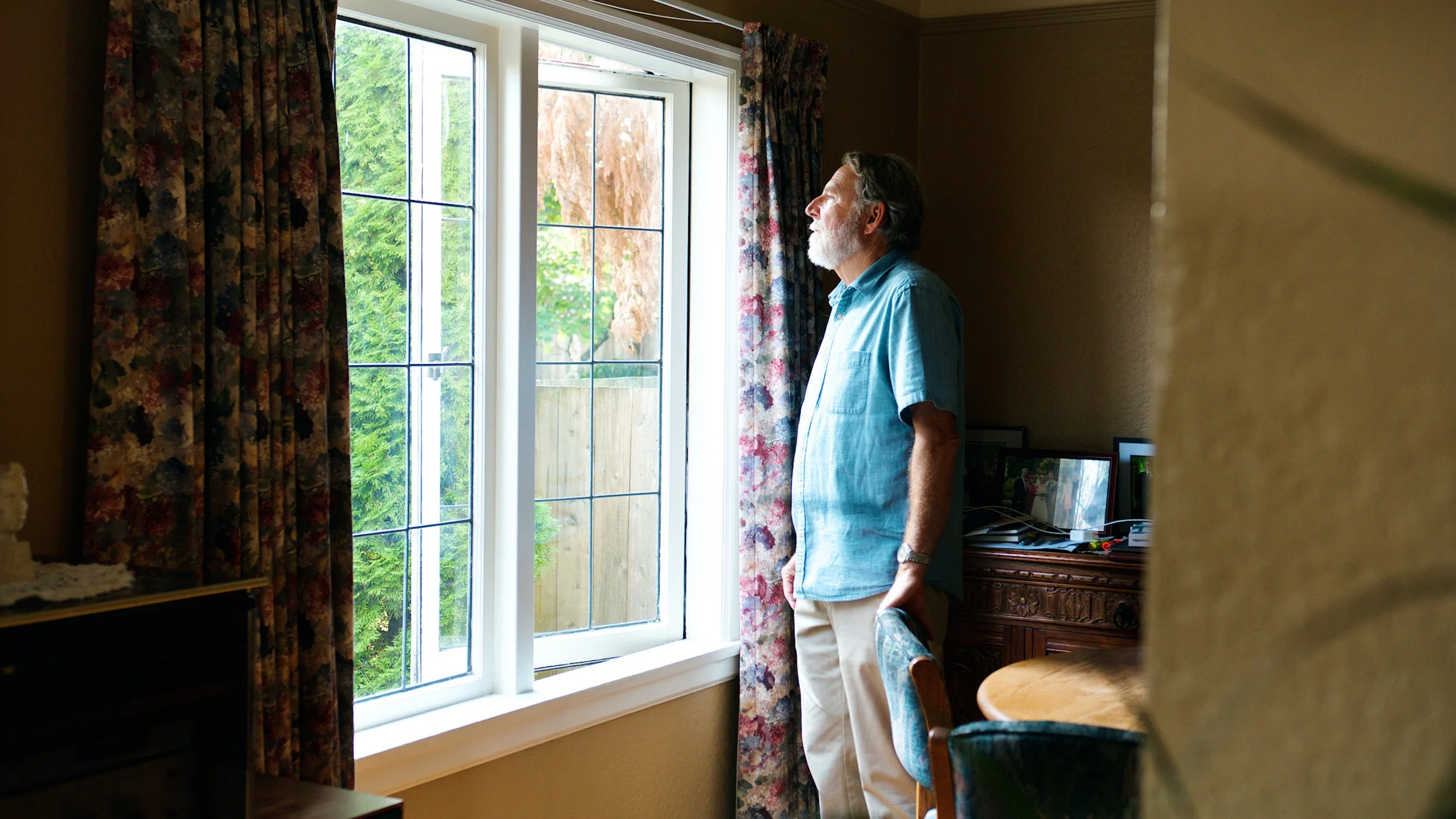 Homeowner standing by a window during an interview filmed for FortisBC.
