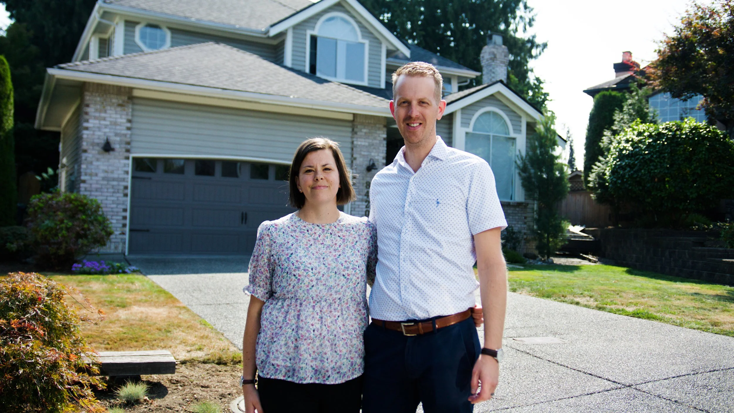 Homeowners standing outside their house during a filmed interview for FortisBC.