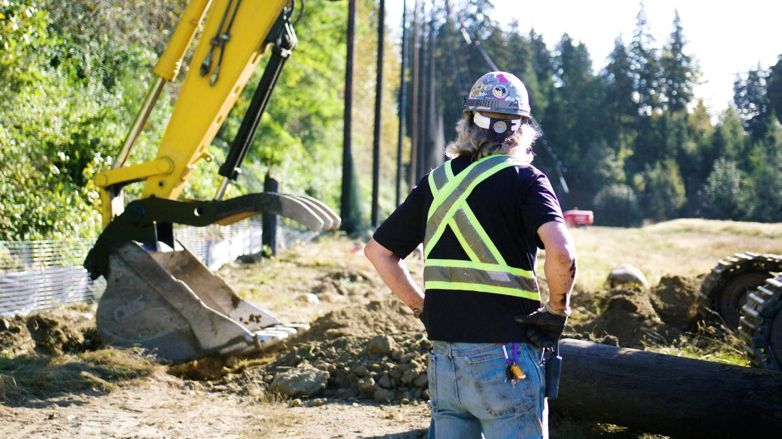 Construction worker overseeing excavation work at a demolition site.
