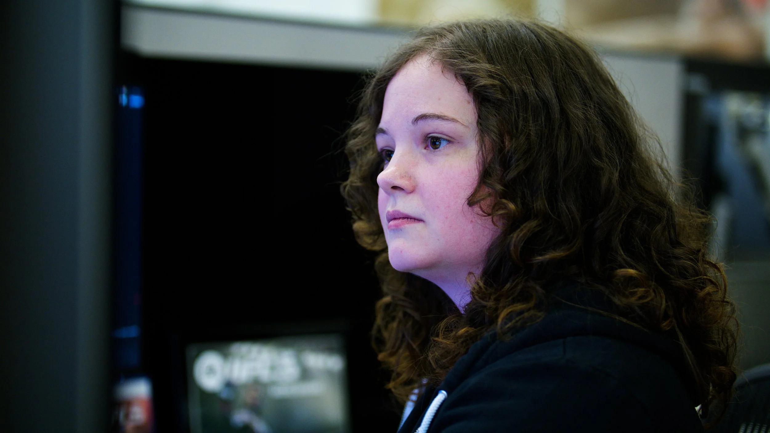 EA Sports team member focused on her computer screen in a game development studio.
