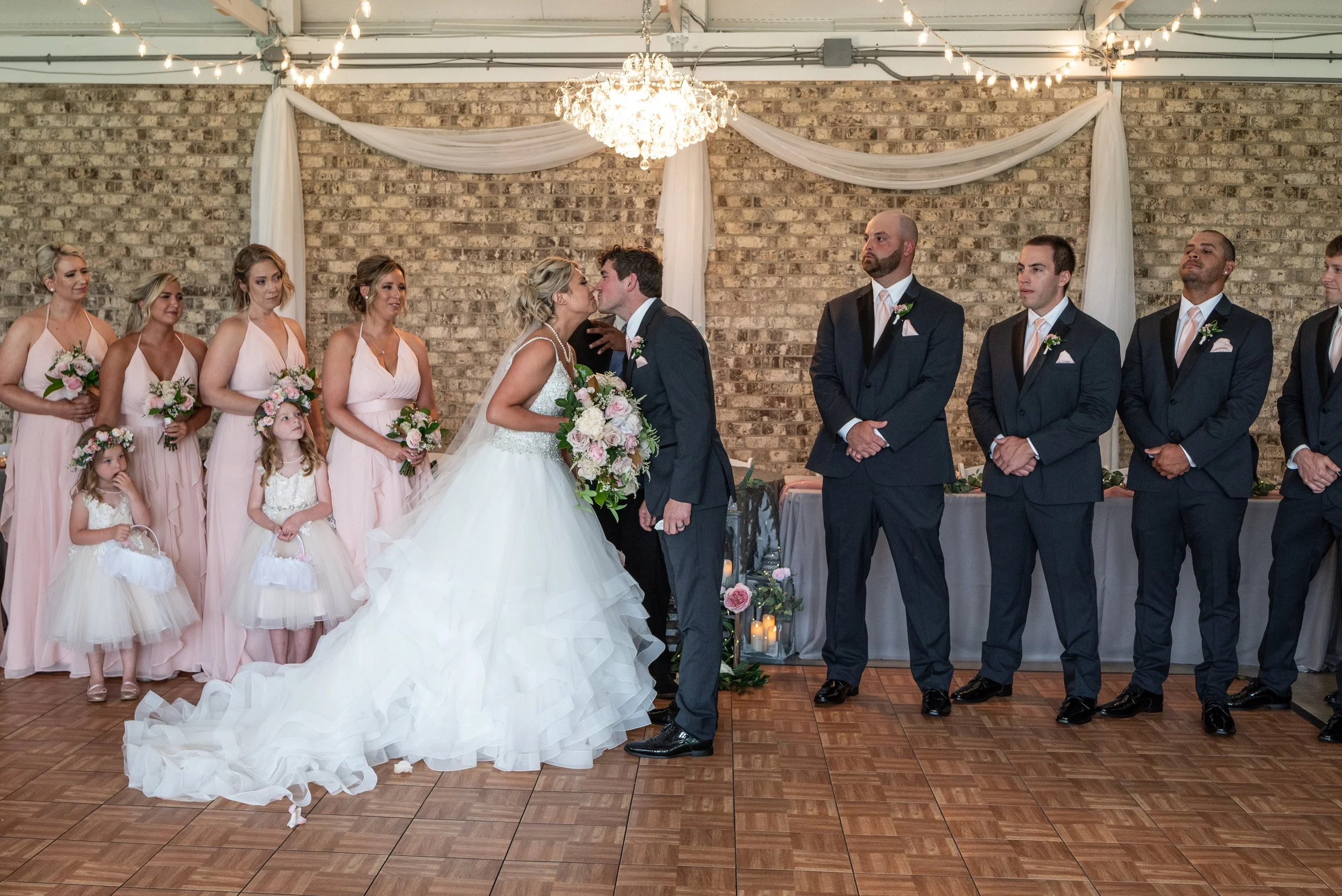 This is a scenic boho rustic view of the inside of The Magnolia Barn award-winning reception hall outdoor barn wedding venue featuring an exposed brick wall with natural light in Miamisburg at Magnolia Estate. Surrounded by the Greater Dayton, Columb