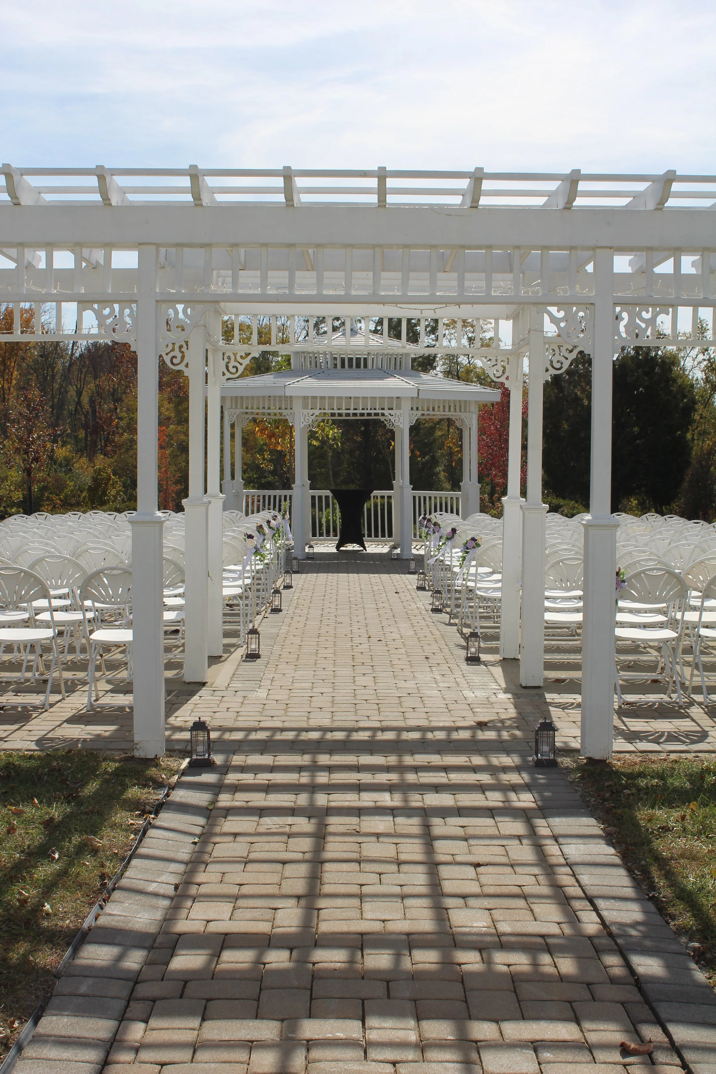 This is a scenic boho rustic view of a Bride and Bridesmaids at the brewery-style cocktail patio of The Magnolia Barn award-winning reception hall outdoor barn wedding venue in Miamisburg at Magnolia Estate. Surrounded by the Greater Dayton, Columbus