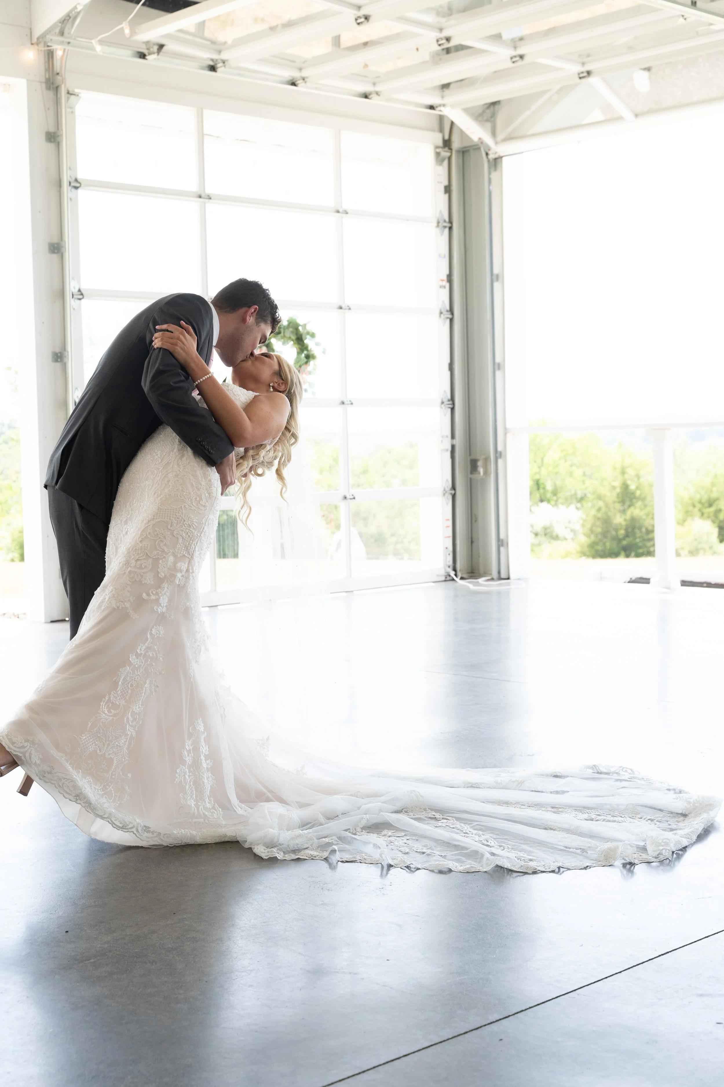 This is a scenic boho rustic view of a Bride and Bridesmaids at the brewery-style cocktail patio of The Magnolia Barn award-winning reception hall outdoor barn wedding venue in Miamisburg at Magnolia Estate. Surrounded by the Greater Dayton, Columbus