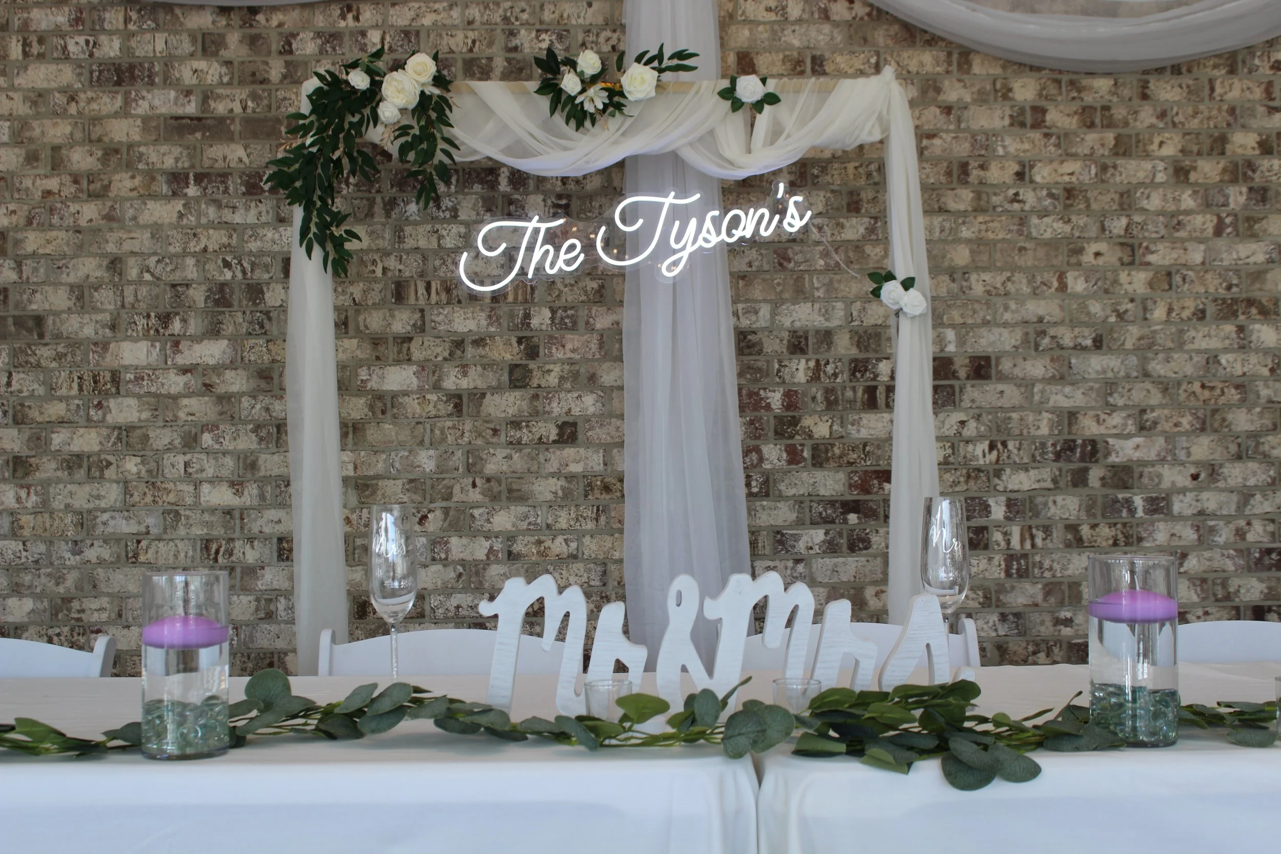 This is a scenic boho rustic view of the inside of The Magnolia Barn award-winning reception hall outdoor barn wedding venue featuring an exposed brick wall with natural light in Miamisburg at Magnolia Estate. Surrounded by the Greater Dayton, Columb