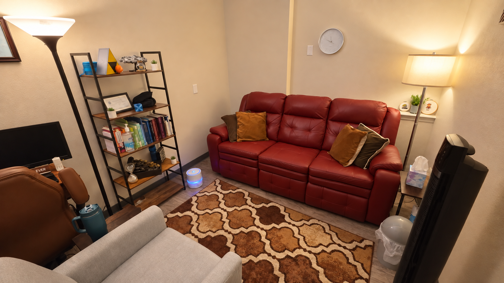 A picture of a therapist office with a couch and chair