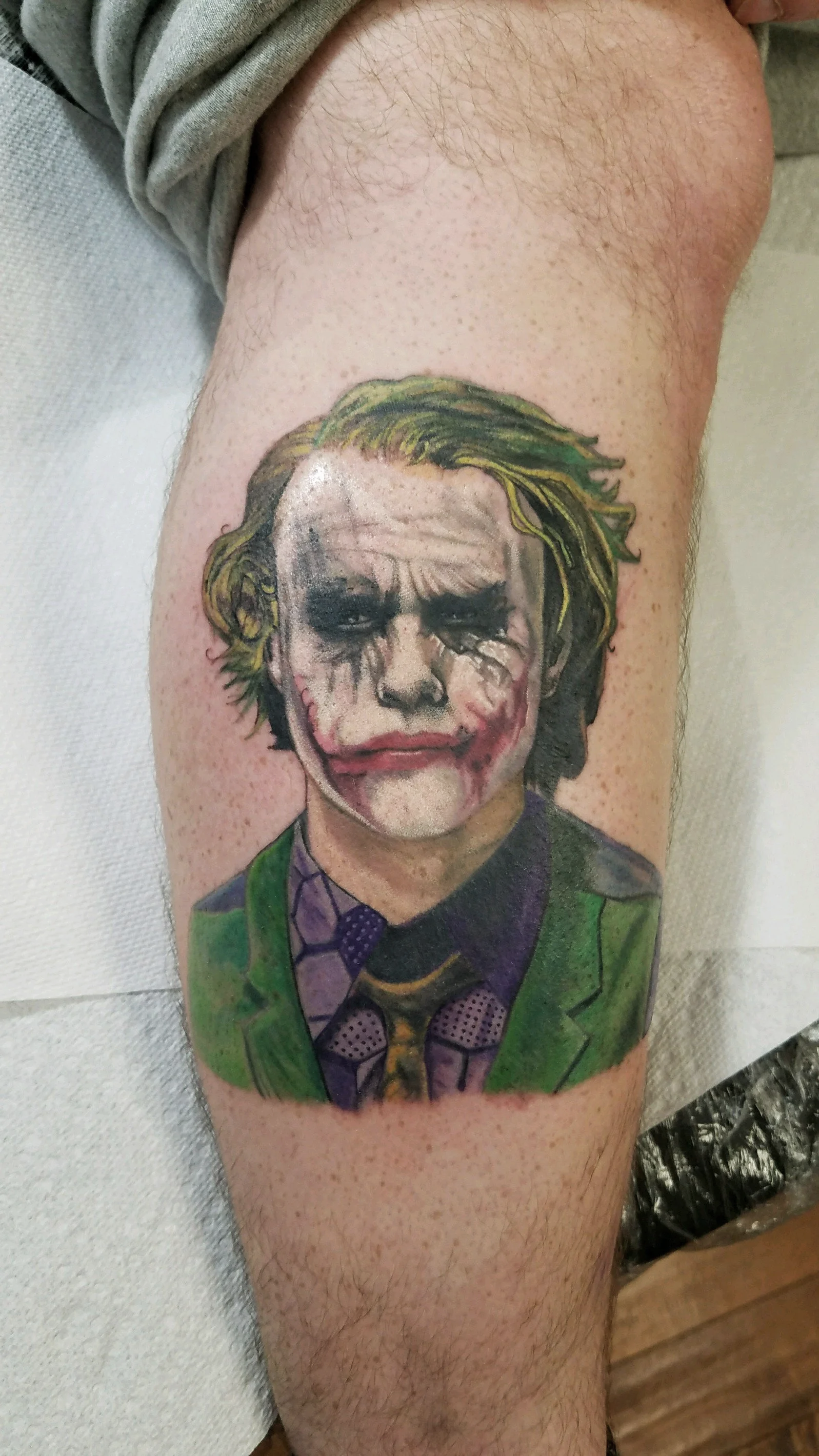 Heath Ledger Joker portrait tattoo inspired by The Dark Knight, featuring detailed color realism and the iconic green hair and red smile, by Salvador Vargas III, serving Bluffton SC, Savannah GA, and Charleston SC.