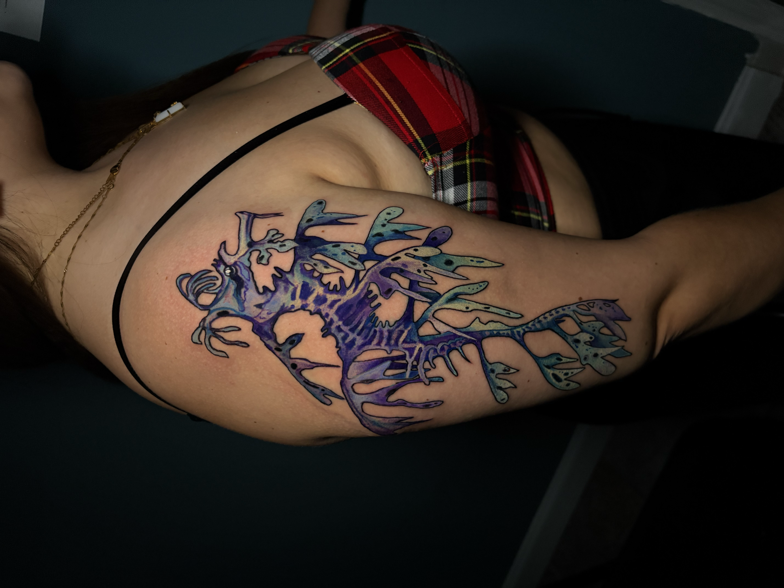 Vibrant watercolor-style skeletal seahorse  tattoo with bold black linework and blue, purple, and teal color by Salvador Vargas III, serving Bluffton SC, Savannah GA, and Charleston SC.