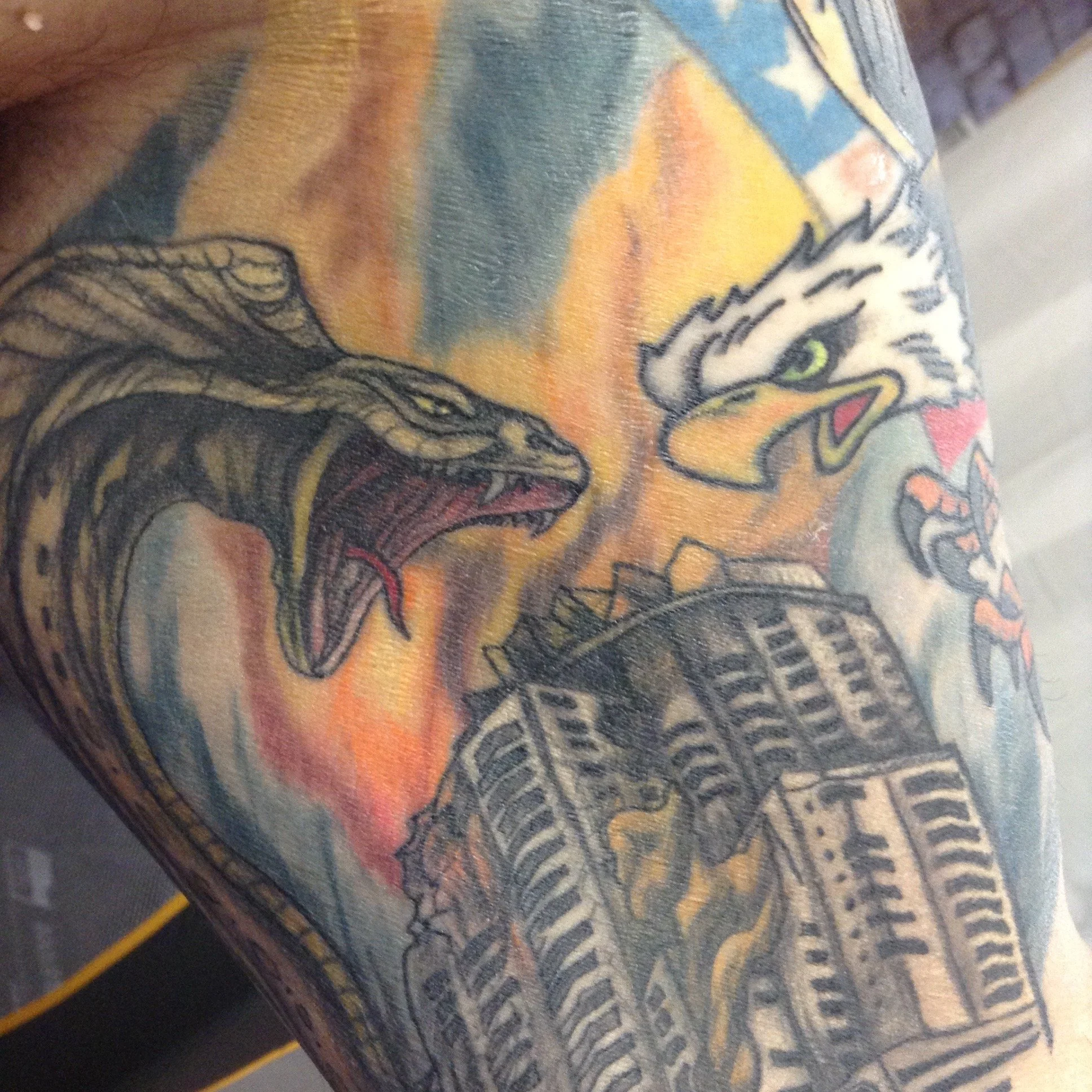 Colorful tattoo featuring two dragons, a building, and vibrant background colors.
