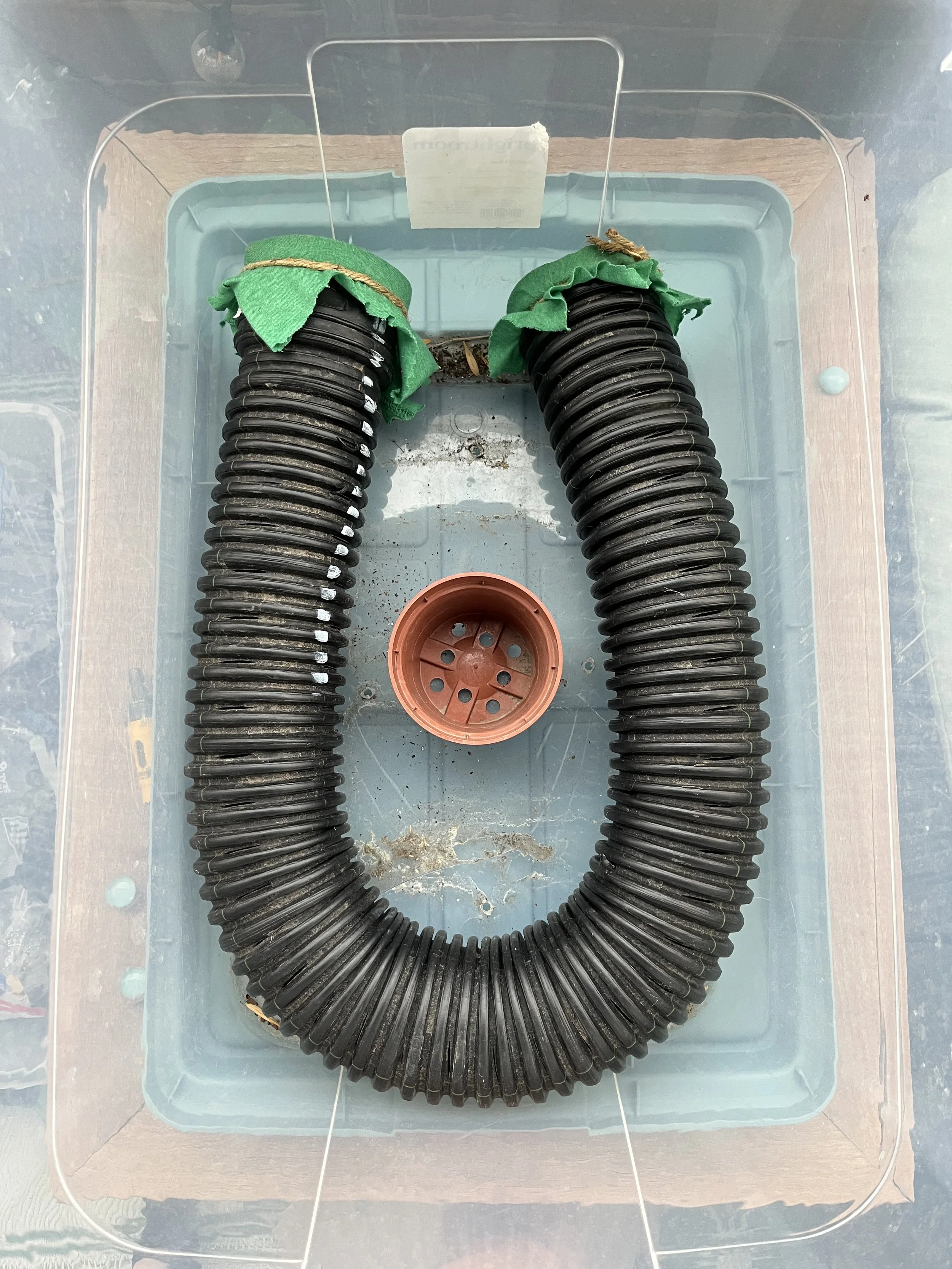 storage containers with PVC pipe and a flower pot in the center.