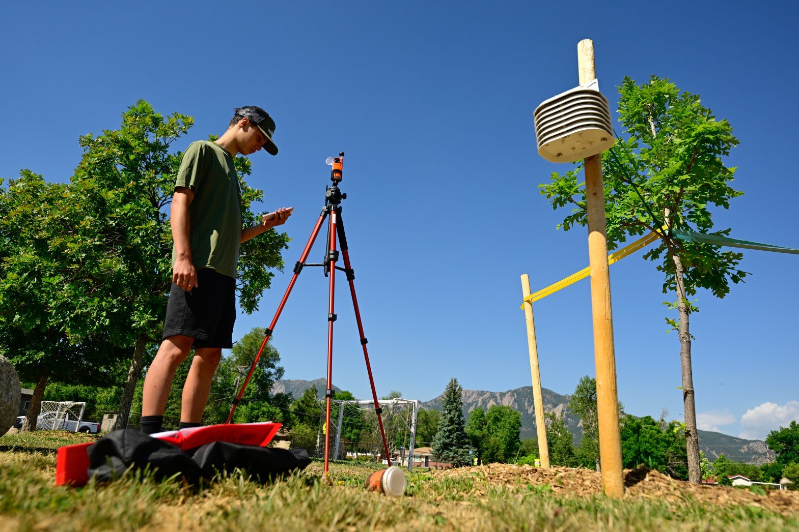 man outside against a blue sky with trees surrounding him. using a heat mapping tool.