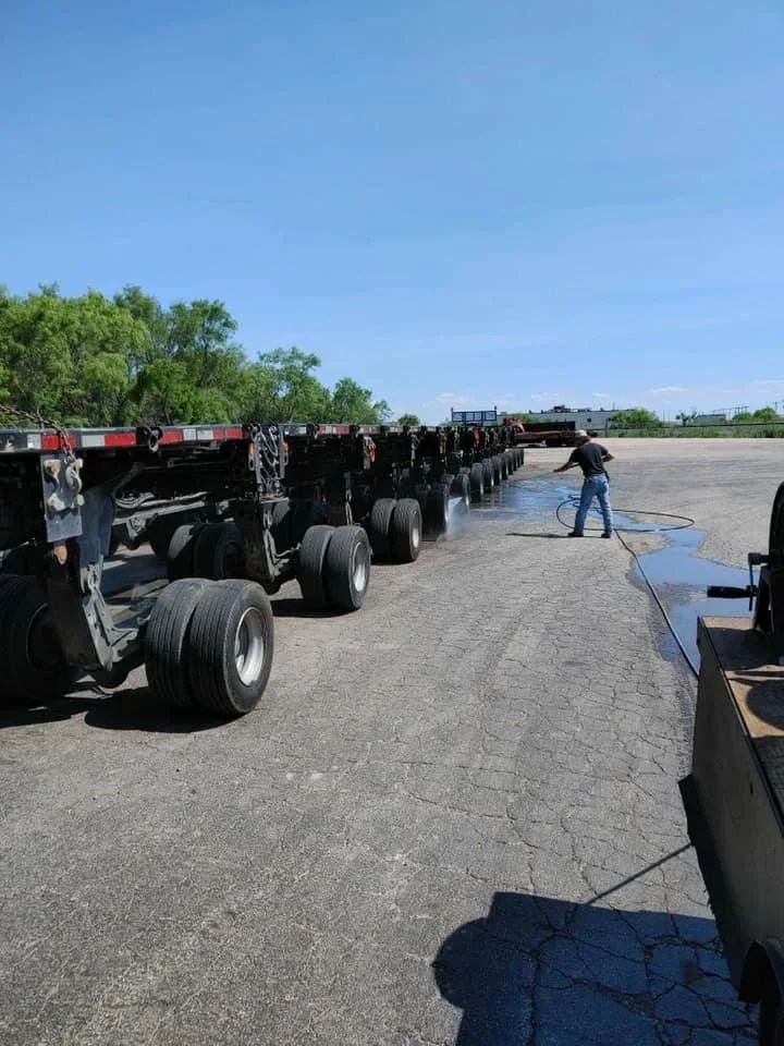 Commercial truck trailers being professionally pressure washed in a fleet lot