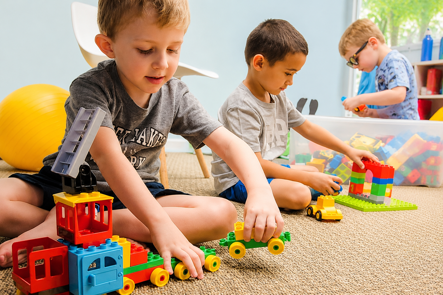 Boys assemble a colorful toy train with much focus and calm.
