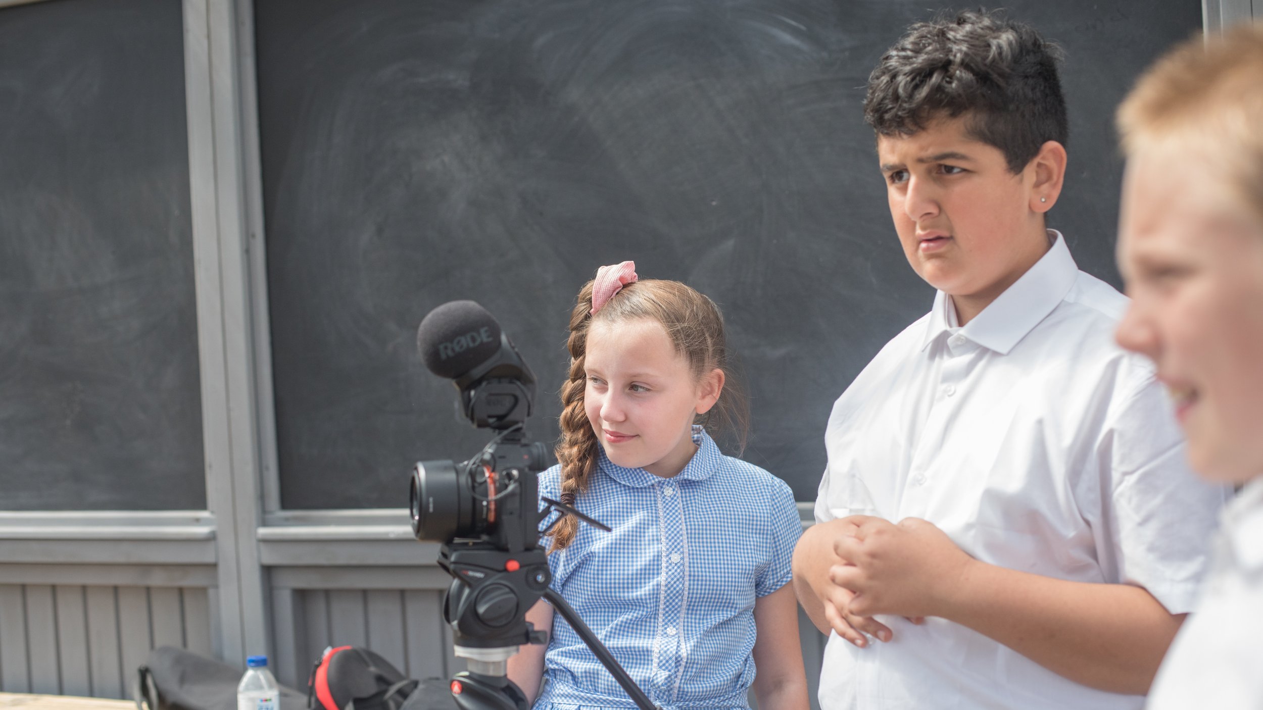 Two students filming an interview for a creative workshop