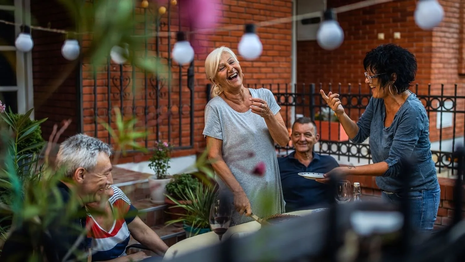 Turning 60 with Simple Living Style (Woman over 60 celebrating dinner at dinner with friends on outdoor patio)