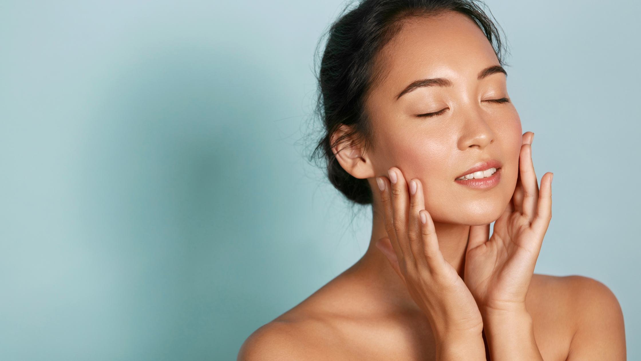 Woman with hands gently touching her cheeks